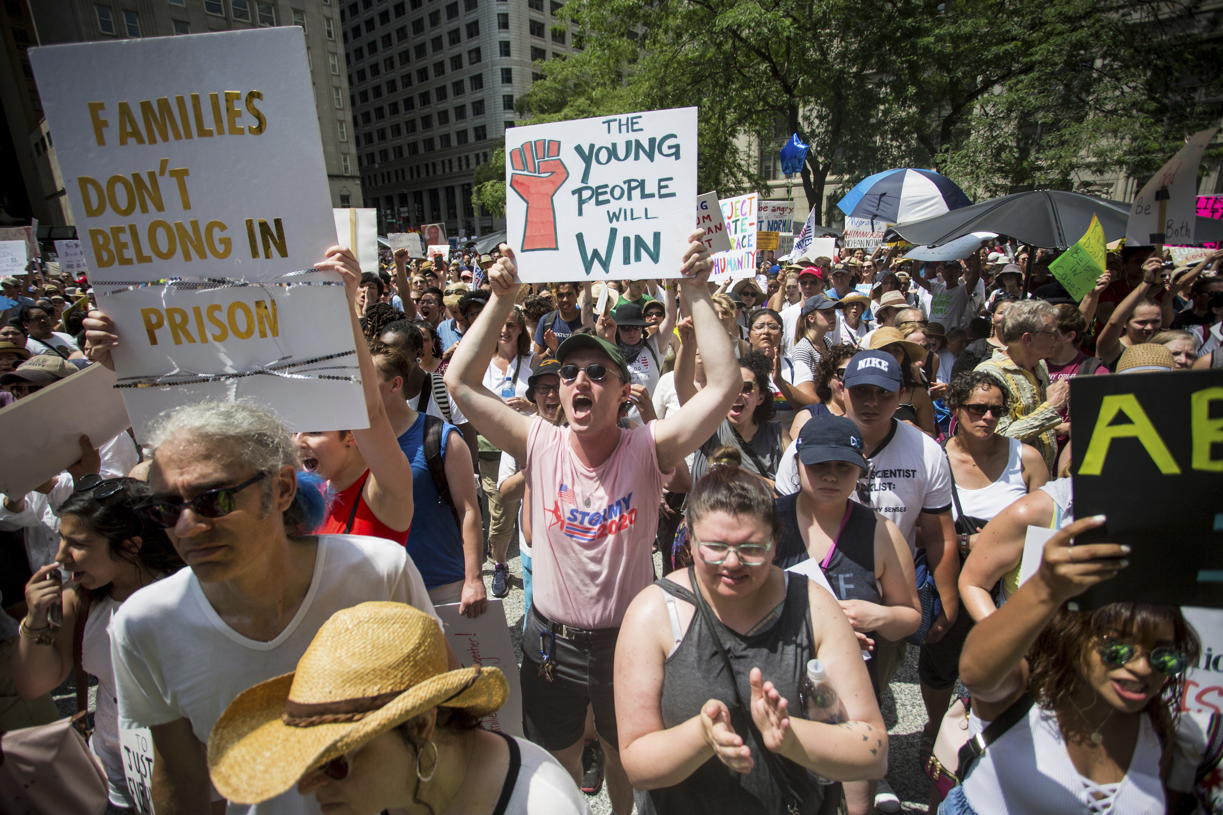 People hold signs as they participate in the Families Belong Together march in Chicago on Saturday, June 30, 2018. In major cities and tiny towns, marchers gathered across America, moved by accounts of children separated from their parents at the U.S.-Mexico border, in the latest act of mass resistance against President Donald Trump's immigration policies. (James Foster/Chicago Sun-Times via AP)