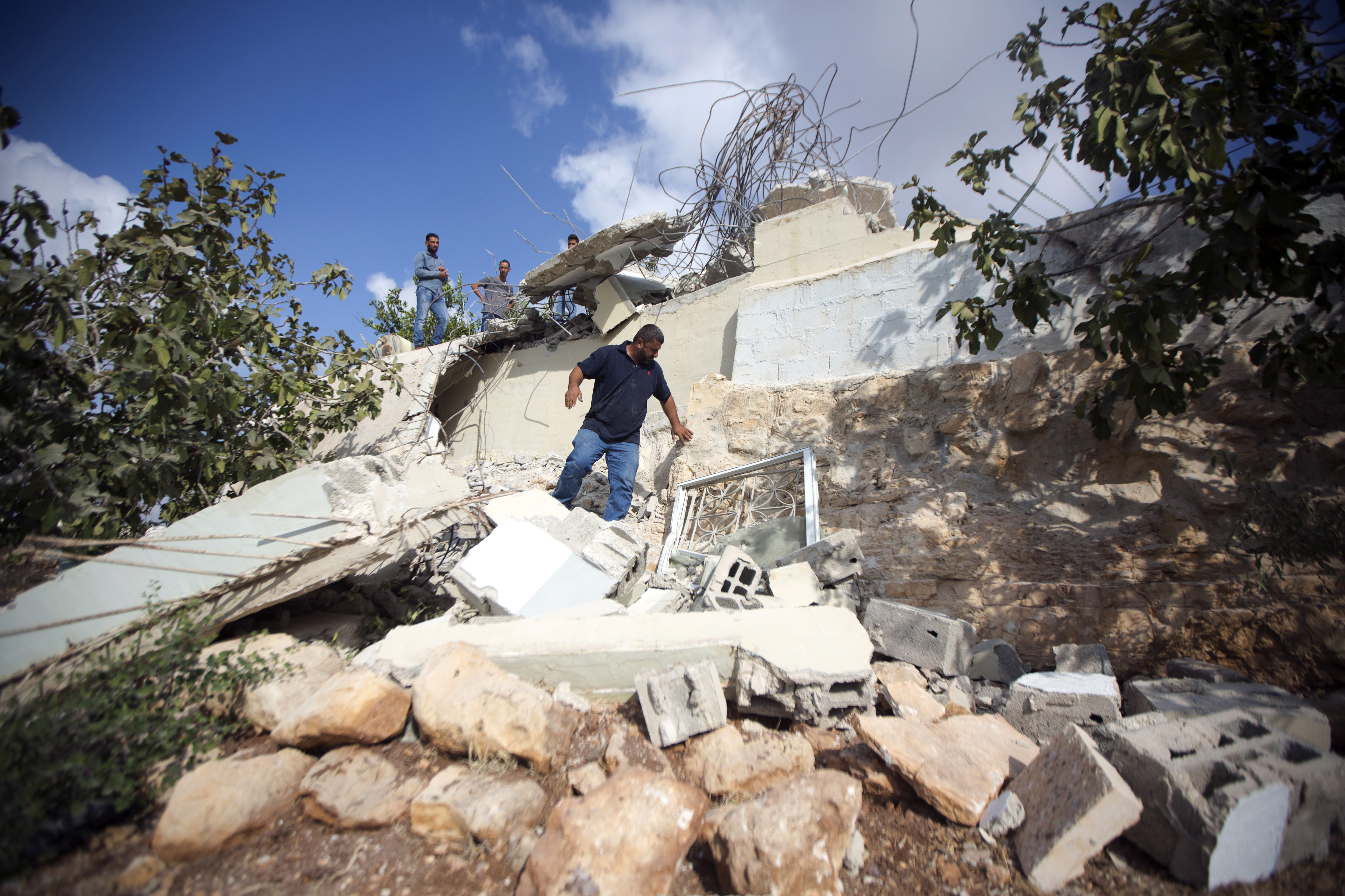 A Palestinian man inspects the house of Muhammad Dar Yusuf after it was demolished by Israeli army, in the West Bank village of Kauber near City of Ramallah, Tuesday, Aug. 28, 2018. The Israeli military says forces demolished the home of a Palestinian who killed an Israeli in a West Bank settlement last month. (AP Photo/Majdi Mohammed)