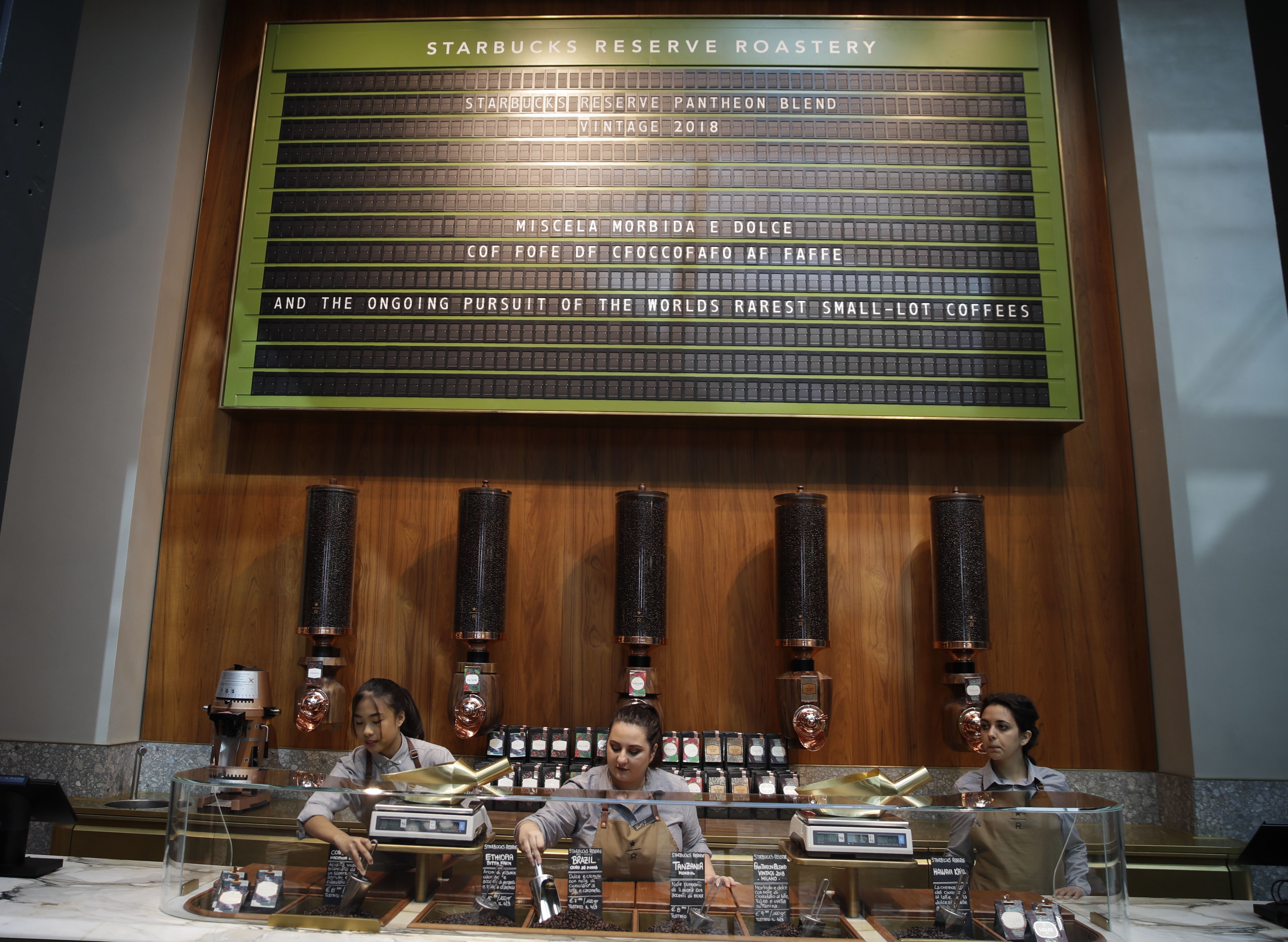 In this photo taken on Tuesday, Sept. 4, 2108, employees work at the Starbucks store in Milan, Italy. Starbucks opens its first store in Italy Friday, betting that premium brews and novelties like a heated marble-topped coffee bar will win patrons in a country fond of its espresso rituals. Decades ago, Milan’s coffee bars had inspired the chain’s vision. Starbucks hopes clients will linger at Starbucks Reserve Roastery, where they can watch beans being roasted, sip Reserve coffee or have cocktails at a mezzanine-level bar in a cavernous space that once was a post office near the city’s Duomo, or cathedral. (AP Photo/Luca Bruno)