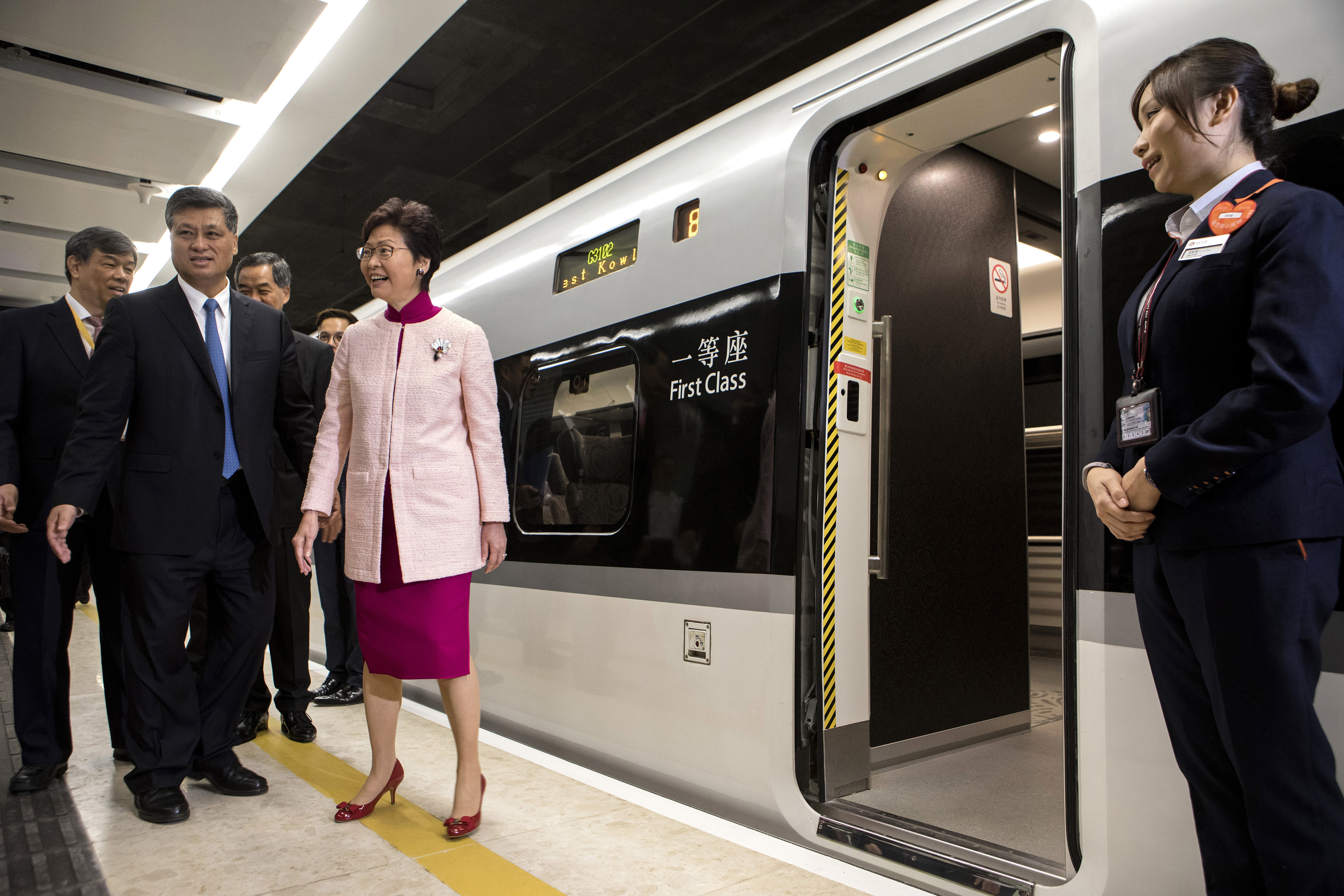 Ma Xingrui, governor of Guangdong Province, front row left, and Carrie Lam, Hong Kong's chief executive, front row second left, stand next to a Guangzhou-Shenzhen-Hong Kong Express Rail Link (XRL) Vibrant Express train bound for Guangzhou Nan Station waits in the Mainland Port Area at West Kowloon Station, which houses the terminal for the XRL in Hong Kong, Saturday, Sept. 22, 2018. (Giulia Marchi/Pool Photo via AP)
