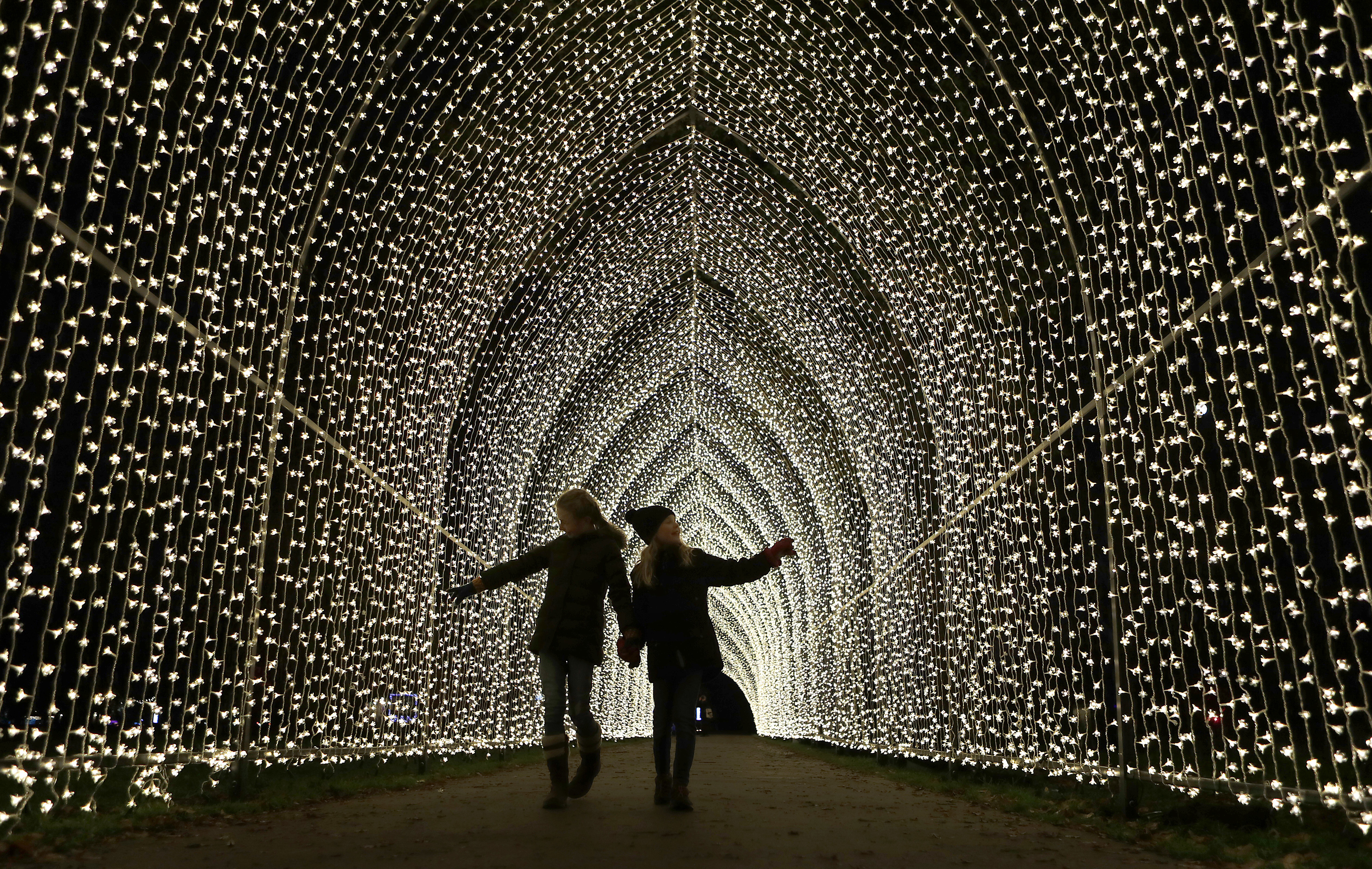Children walk through the Cathedral of Light as part of the illuminated trail through Kew Gardens magnificent after-dark landscape, lit up by over one million twinkling lights in London, Wednesday, Nov. 21, 2018. The spectacular light and sound installations run from 22, November 2018 – 5, January 2019.(AP Photo/Frank Augstein)