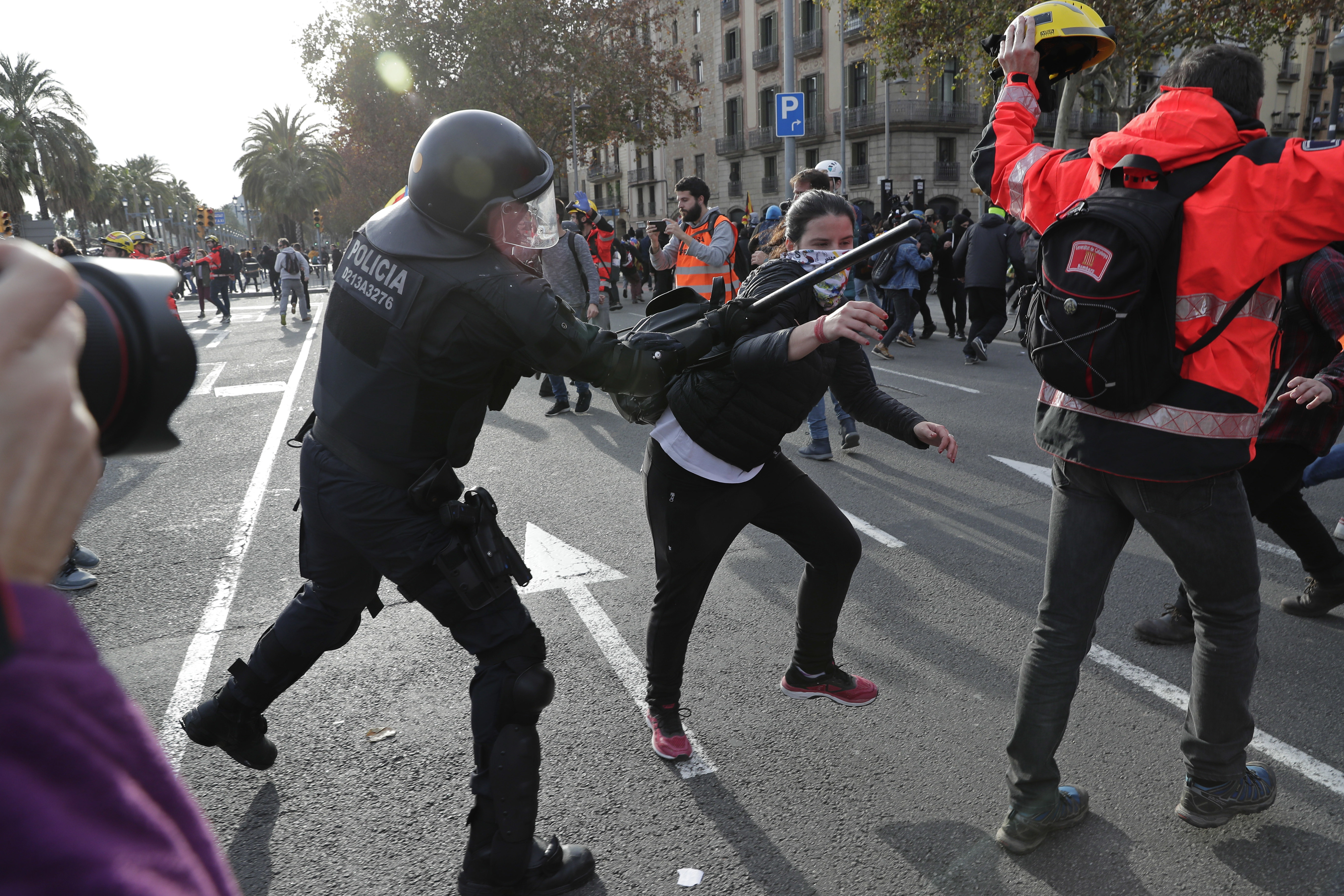 A police officer beats a demonstrator during a protest against Spain's cabinet holding a meeting in Barcelona Spain, Friday Dec. 21, 2018. Scuffles broke out between protesters trying to reach the venue of the cabinet meeting and police trying to stop them on Friday in central Barcelona after pro-independence organizations called for peaceful demonstrations against the meeting across the city. (AP Photo/Manu Fernandez)