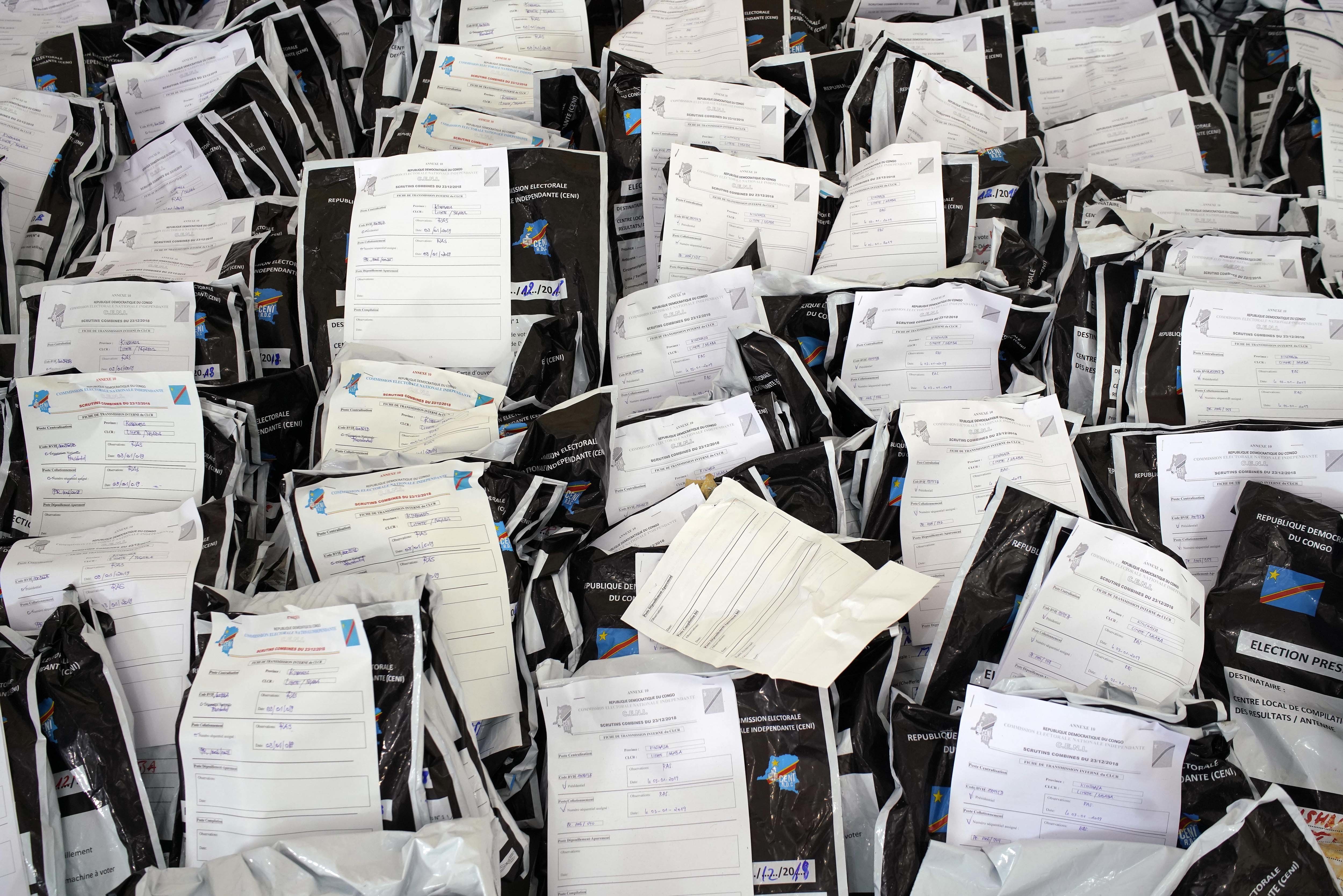 Envelopes containing presidential ballots wait to be counted by Congolese independent electoral commission (CENI) officials at a local results compilation center in Kinshasa, Congo, Friday Jan. 4, 2019. CENI said Thursday the results from 20% of the polling stations have been collected. (AP Photo/Jerome Delay)