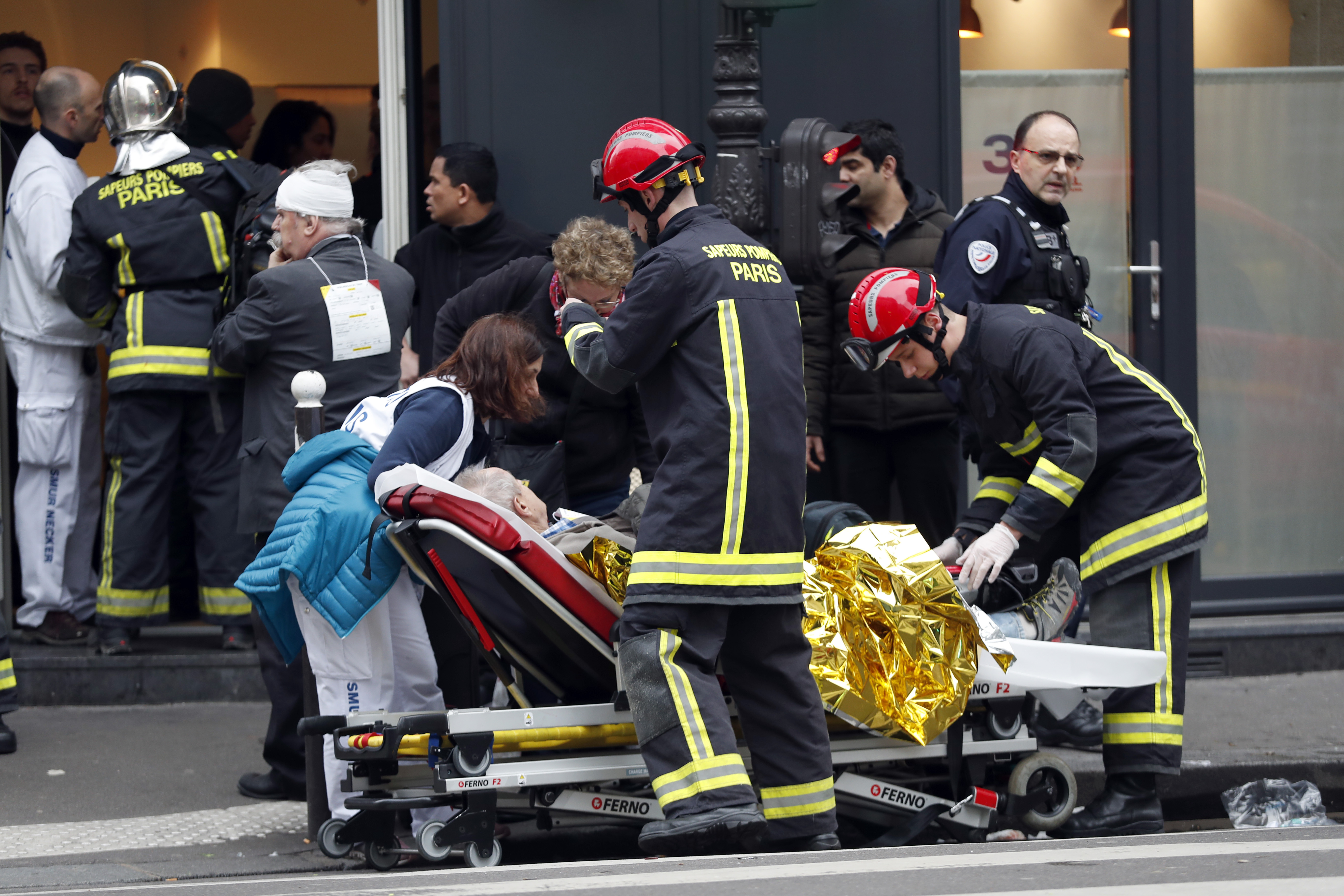 Medical staff and firefighters tend to a wounded man at the scene of a gas leak explosion in Paris, France, Saturday, Jan. 12, 2019. Paris police say several people have been injured in an explosion and fire at a bakery believed caused by a gas leak. (AP Photo/Thibault Camus)