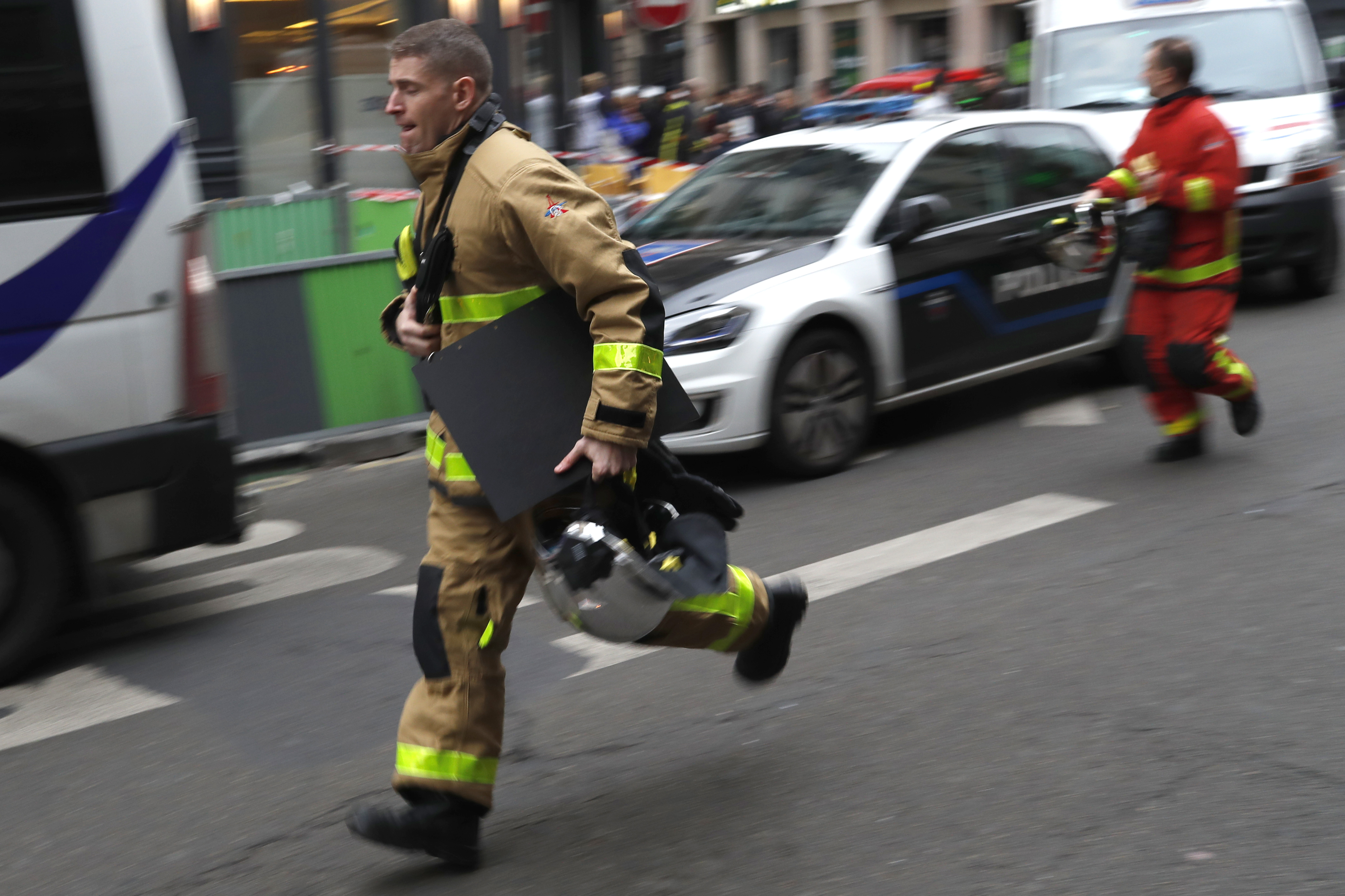 A firefighter rushes to the scene of a gas leak explosion in Paris, France, Saturday, Jan. 12, 2019. A powerful explosion and fire apparently caused by a gas leak at a Paris bakery Saturday injured several people, blasted out windows and overturned cars, police said. (AP Photo/Thibault Camus)