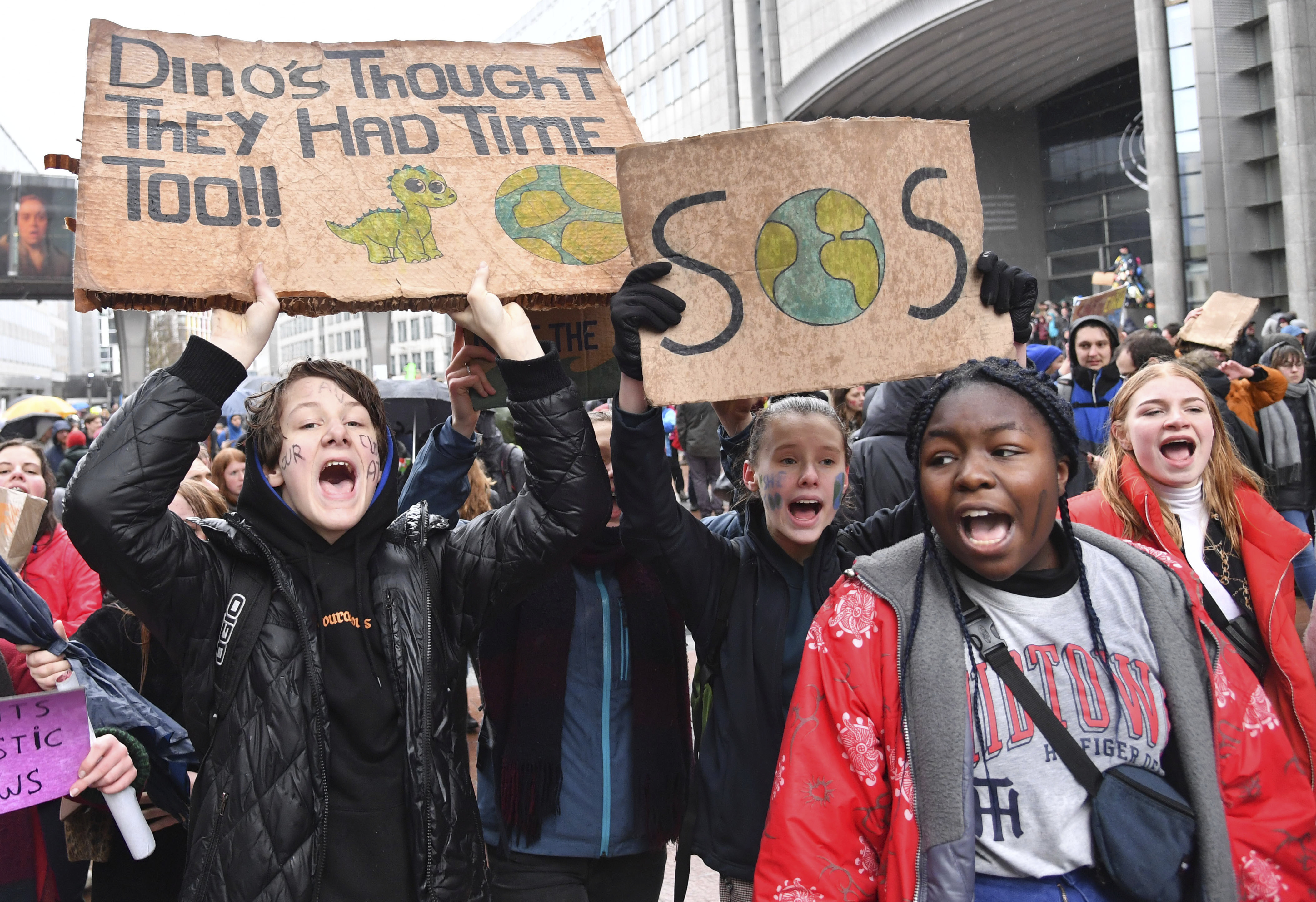 Protestors hold placards as they march during a Rise for the Climate demonstration in Brussels, Sunday, Jan. 27, 2019. (AP Photo/Geert Vanden Wijngaert)