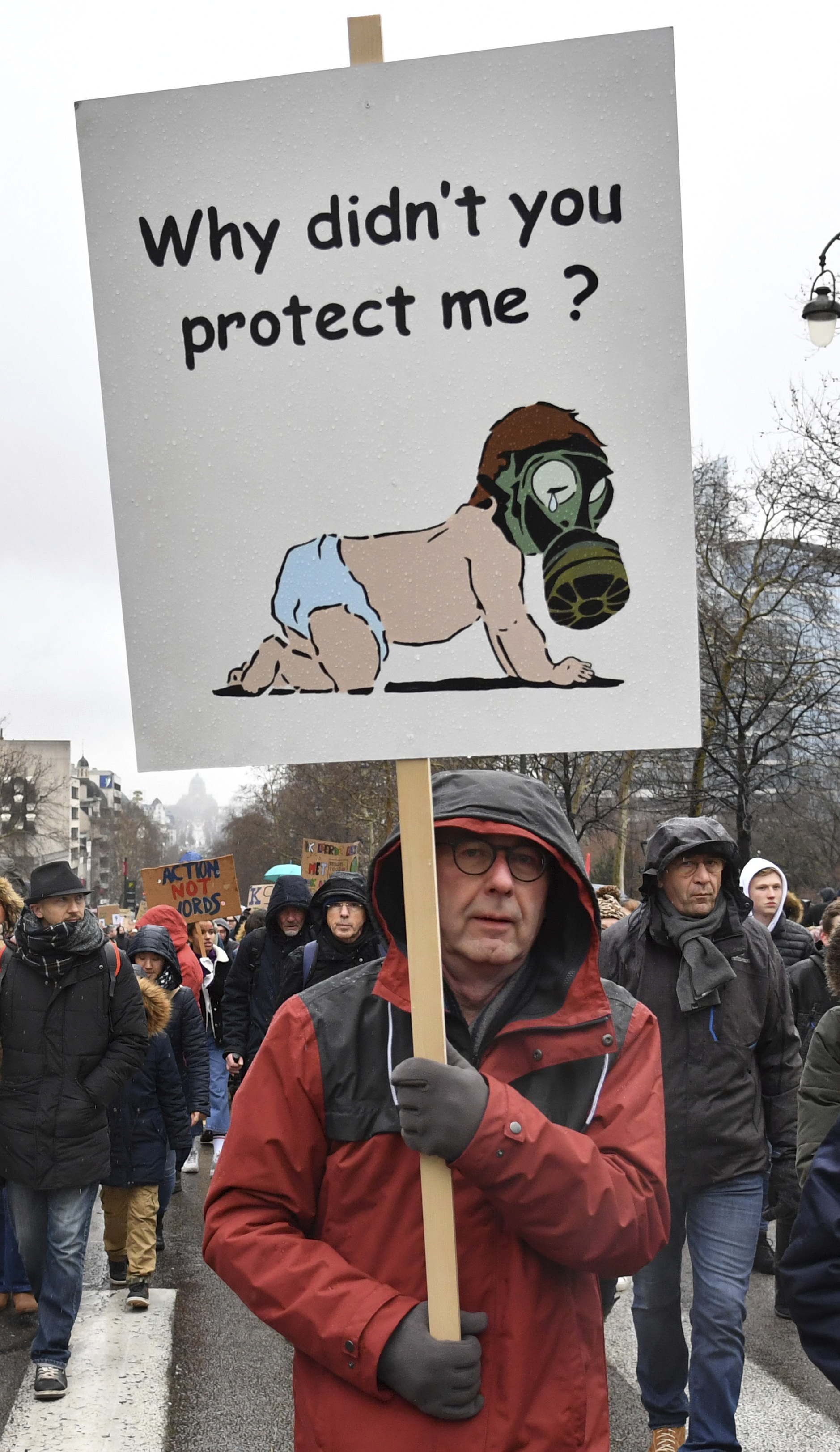 A protestor holds a placard as he marches during a Rise for the Climate demonstration in Brussels, Sunday, Jan. 27, 2019. (AP Photo/Geert Vanden Wijngaert)