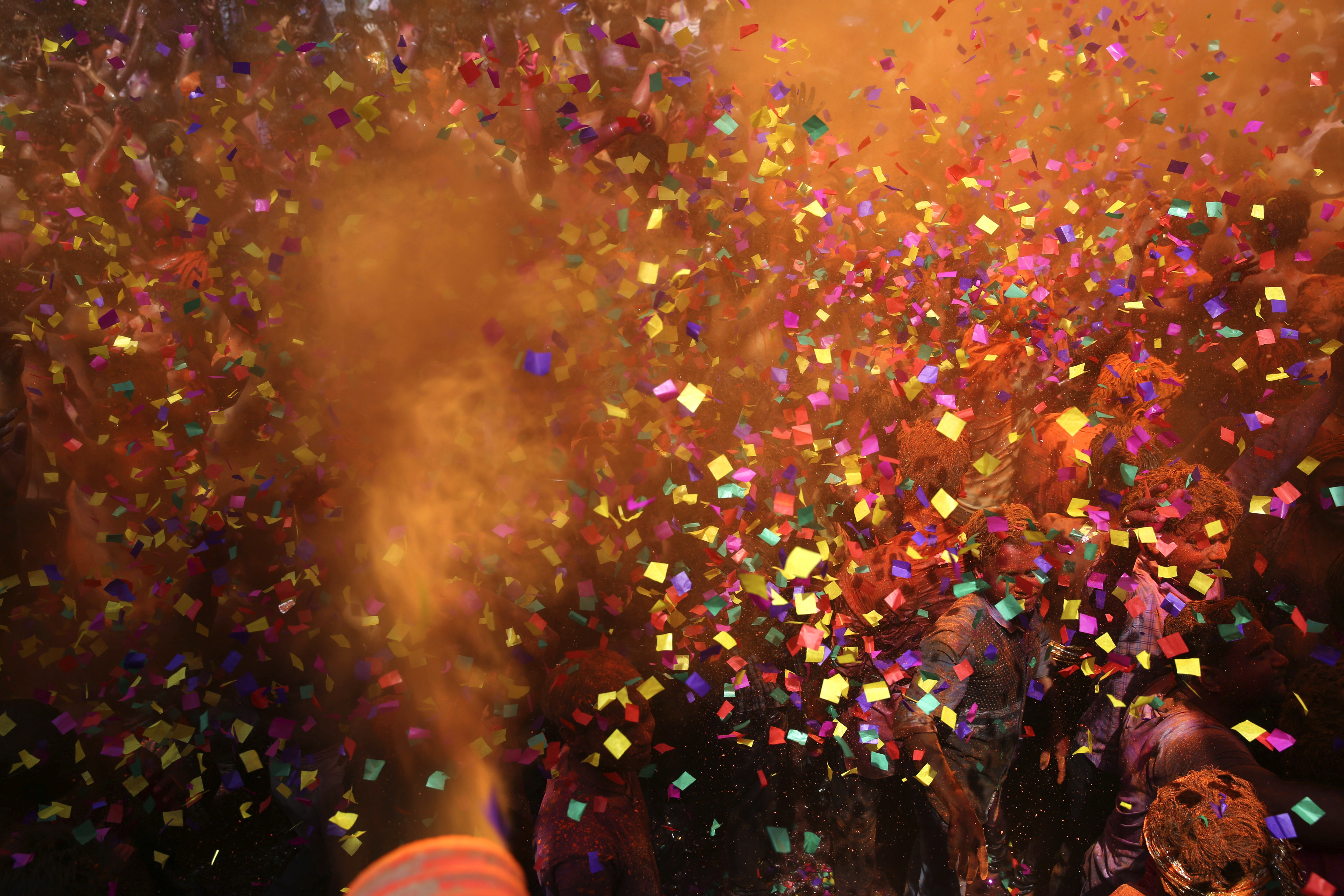 Indian revelers dance as colored powder and confetti are showered on them during celebrations to mark Holi, the Hindu festival of colors, in Prayagraj, India, Friday, March 22, 2019. Indians on Thursday celebrated Holi, the riotous annual celebration of color, that marks the end of winter and the arrival of spring. People armed with water balloons, colored water and powder in multiple hues played Holi by smearing each other's faces with color. (AP Photo/ Rajesh Kumar Singh)