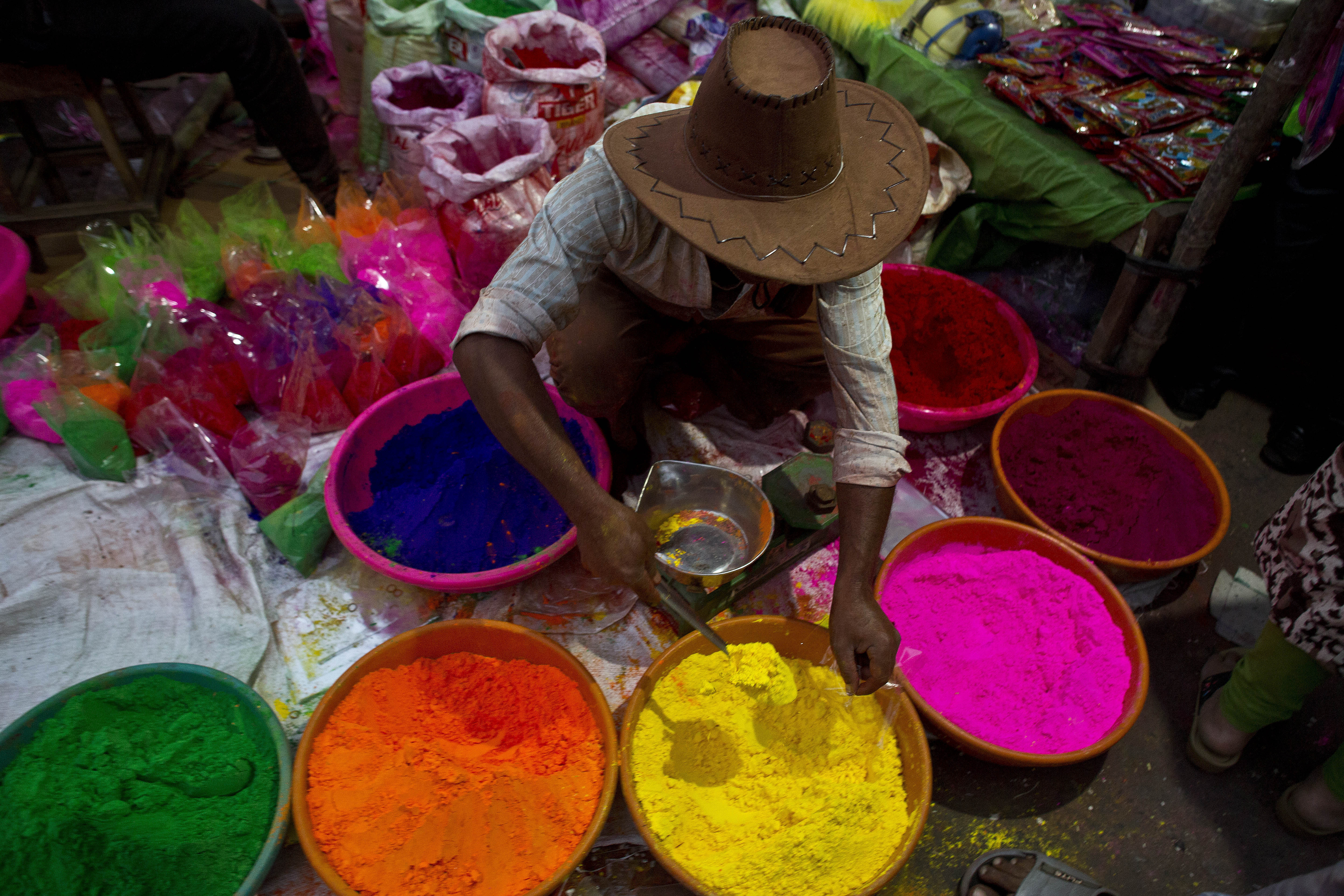 An Indian street vendor sells colored powder a day ahead of Holi, the festival of colors, in Gauhati, India, Wednesday, March 20, 2019. Holi also marks the advent of Spring season. (AP Photo/Anupam Nath)