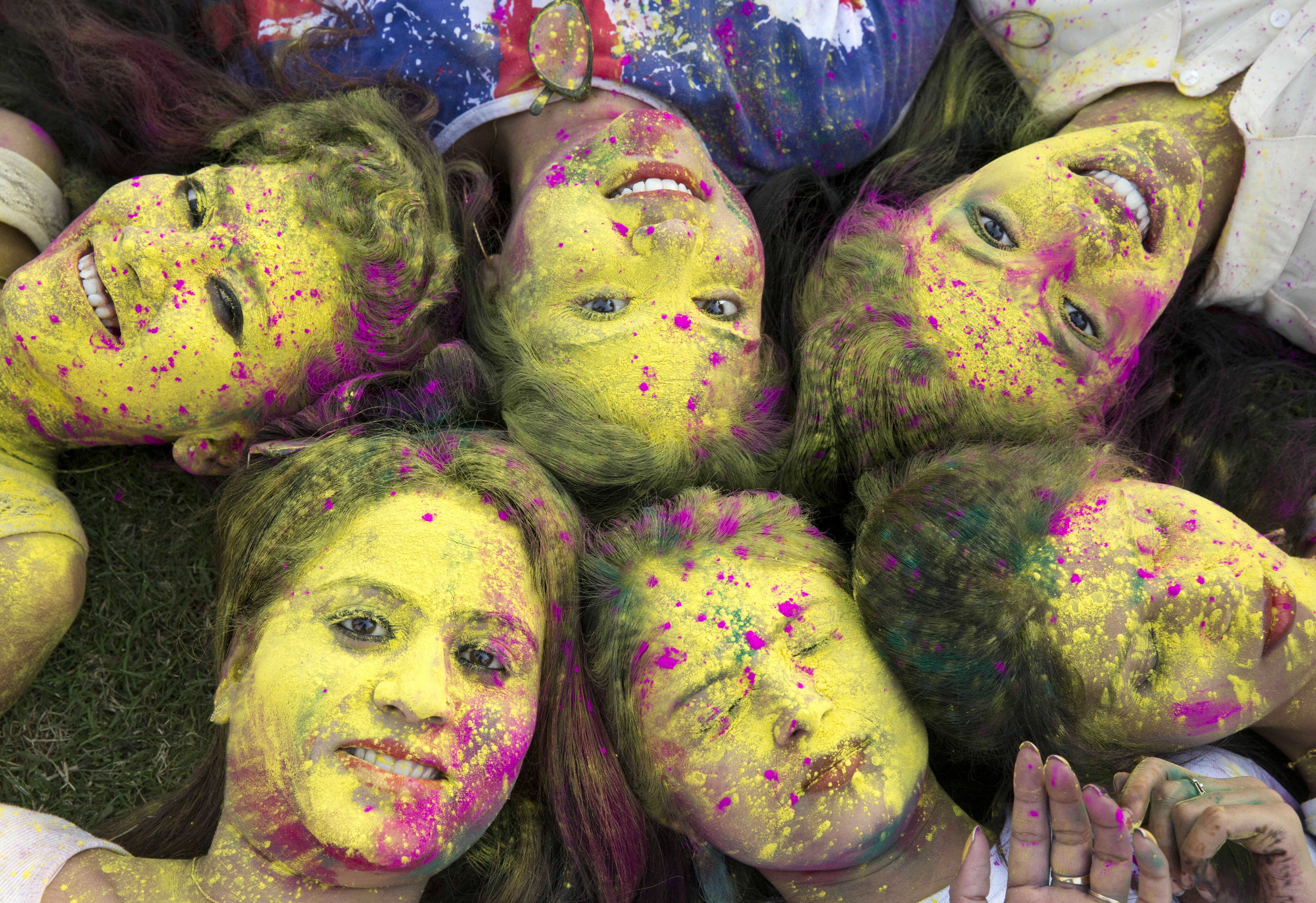 In this Wednesday, March 20, 2019 photo, Indian girls, faces smeared with color, pose for a photograph during Holi festival celebrations in Allahabad, India. The Hindu festival of colors also marks the advent of spring. (AP Photo/Rajesh Kumar Singh)