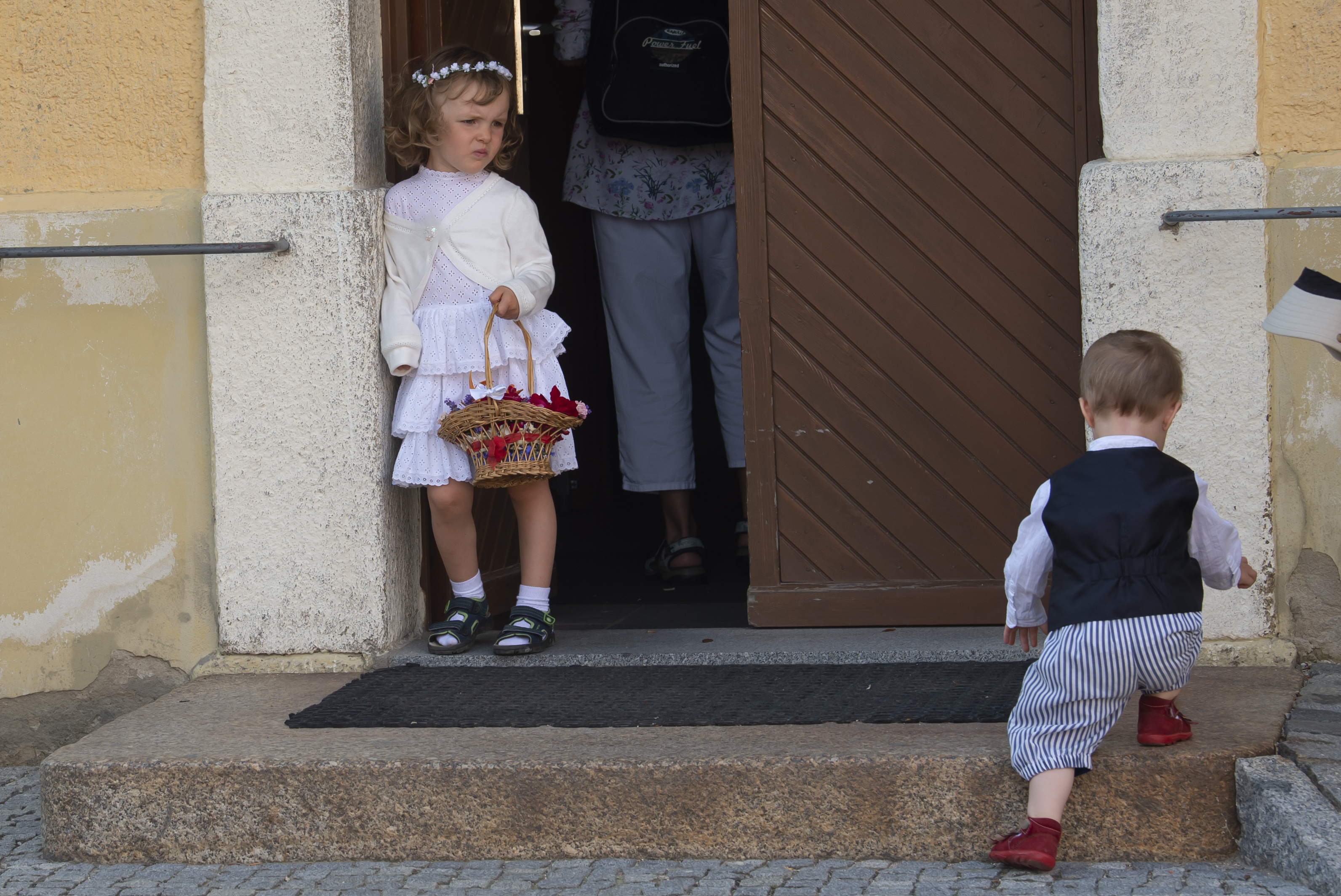 Three years old child Milena, left, dressed in the traditional clothes of the Sorbs waits in front of the church entrance during a holy mass during a Corpus Christi procession in Crostwitz, Germany, Thursday, June 20, 2019. The catholic faithful Sorbs are acknowledged as a national minority near the German-Polish border with their own language in eastern Germany. The procession to commemorate the solemnity of the body and blood of Christ has been a tradition in Lusatia (Lausitz) region. (AP Photo/Jens Meyer)