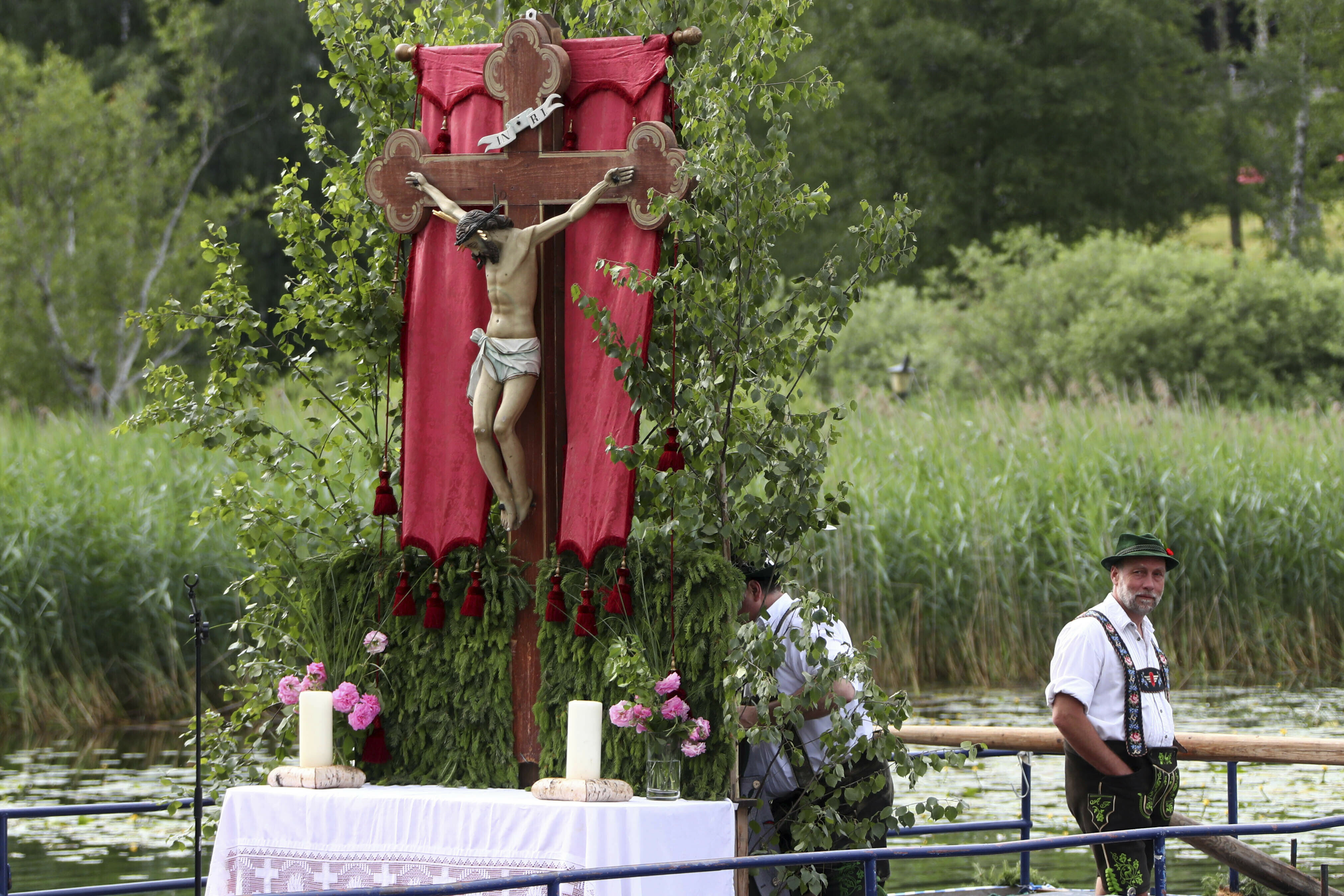 People dressed in traditional clothes wait for the start of a Corpus Christi procession at lake Staffelsee in Seehausen near Murnau, Germany, Thursday, June 20, 2019. (AP Photo/Matthias Schrader)