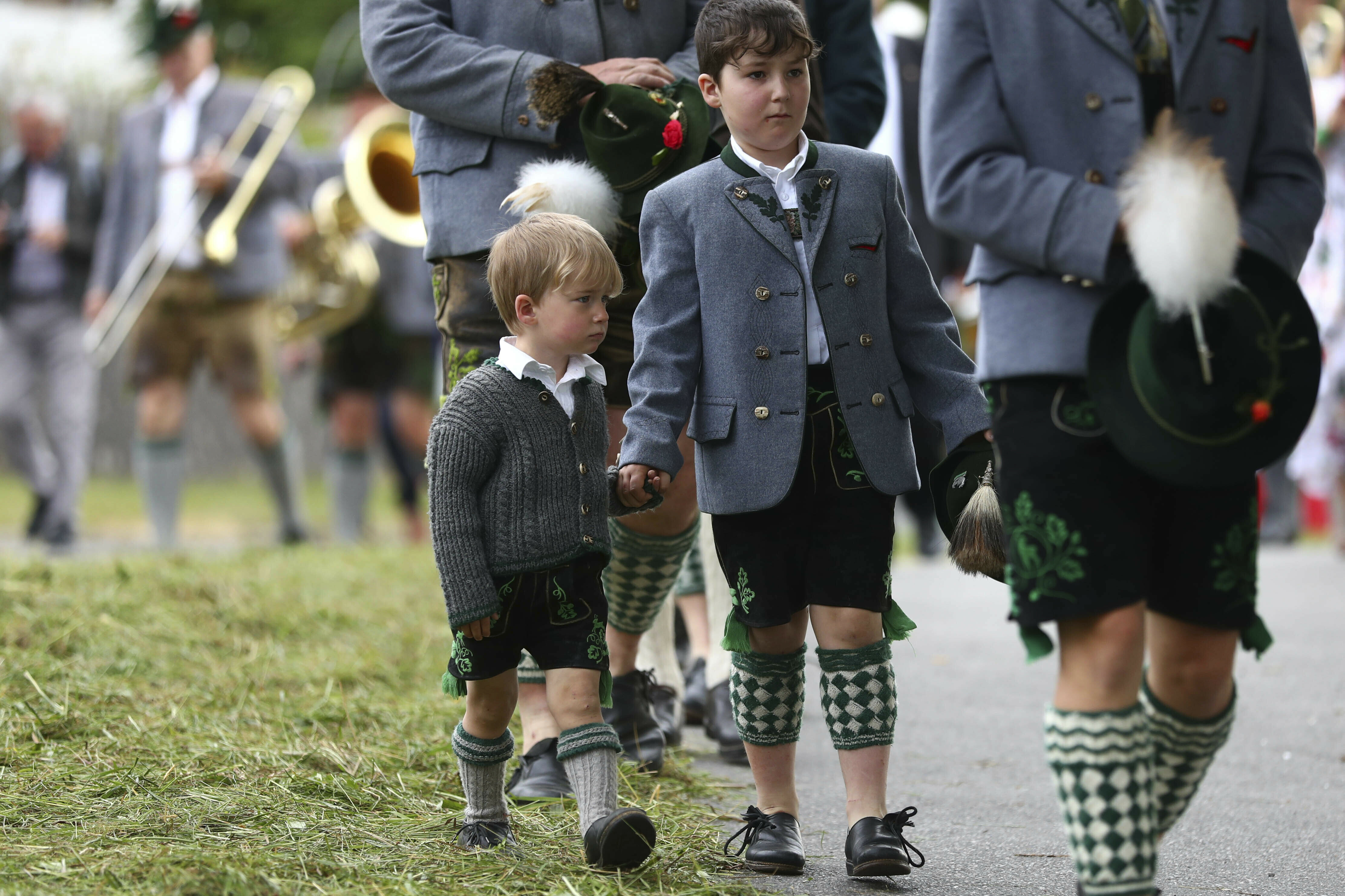 Young boys dressed in traditional clothes wait for the start of a Corpus Christi procession at lake Staffelsee in Seehausen near Murnau, Germany, Thursday, June 20, 2019. (AP Photo/Matthias Schrader)