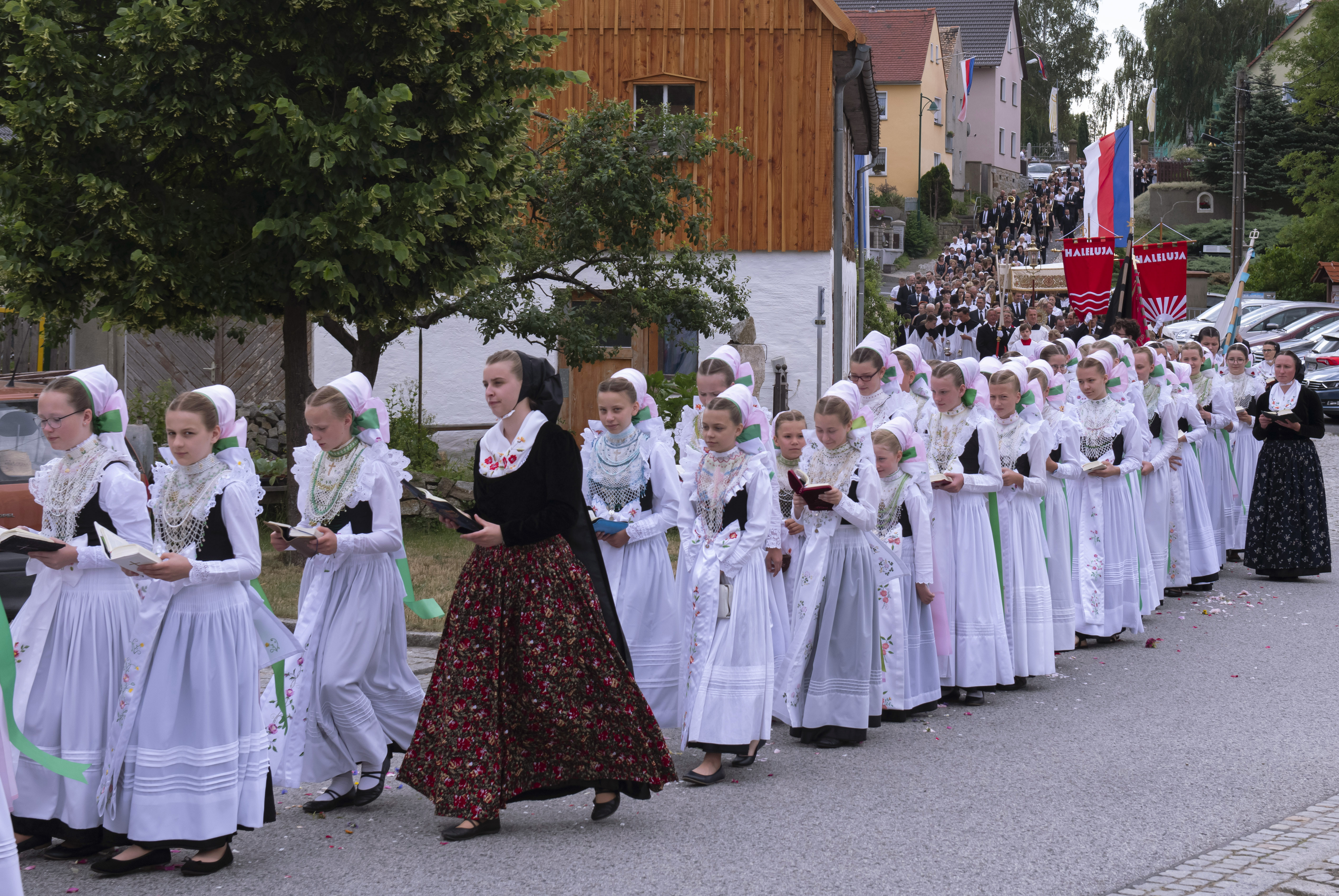 People dressed in the traditional clothes of the Sorbs attend a Corpus Christi procession in Crostwitz, Germany, Thursday, June 20, 2019. The catholic faithful Sorbs are acknowledged as a national minority near the German-Polish border with their own language in eastern Germany. The procession to commemorate the solemnity of the body and blood of Christ has been a tradition in Lusatia (Lausitz) region. (AP Photo/Jens Meyer)