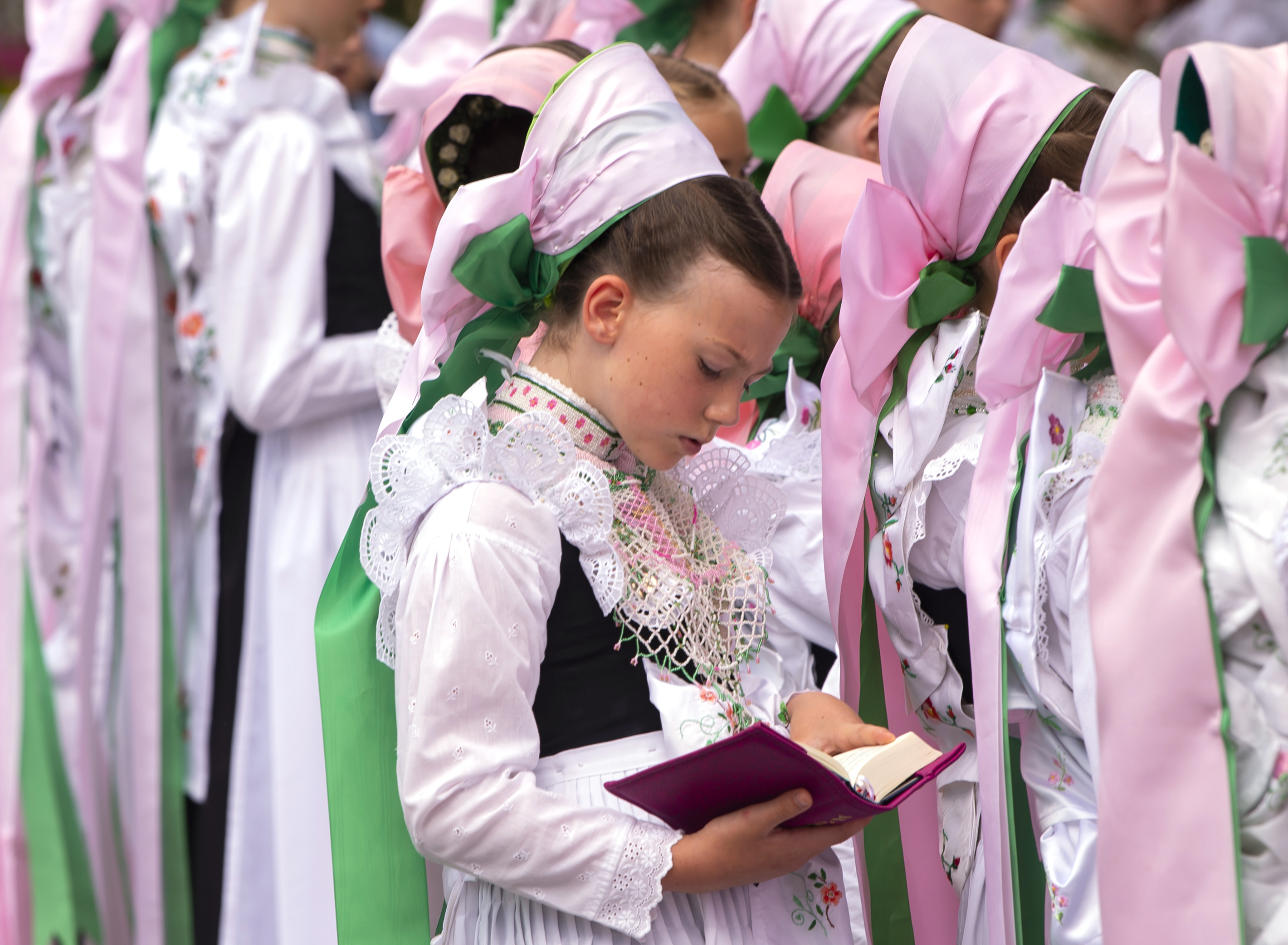 Children dressed in the traditional clothes of the Sorbs attend a Corpus Christi procession in Crostwitz, Germany, Thursday, June 20, 2019. The catholic faithful Sorbs are acknowledged as a national minority near the German-Polish border with their own language in eastern Germany. The procession to commemorate the solemnity of the body and blood of Christ has been a tradition in Lusatia (Lausitz) region. (AP Photo/Jens Meyer)