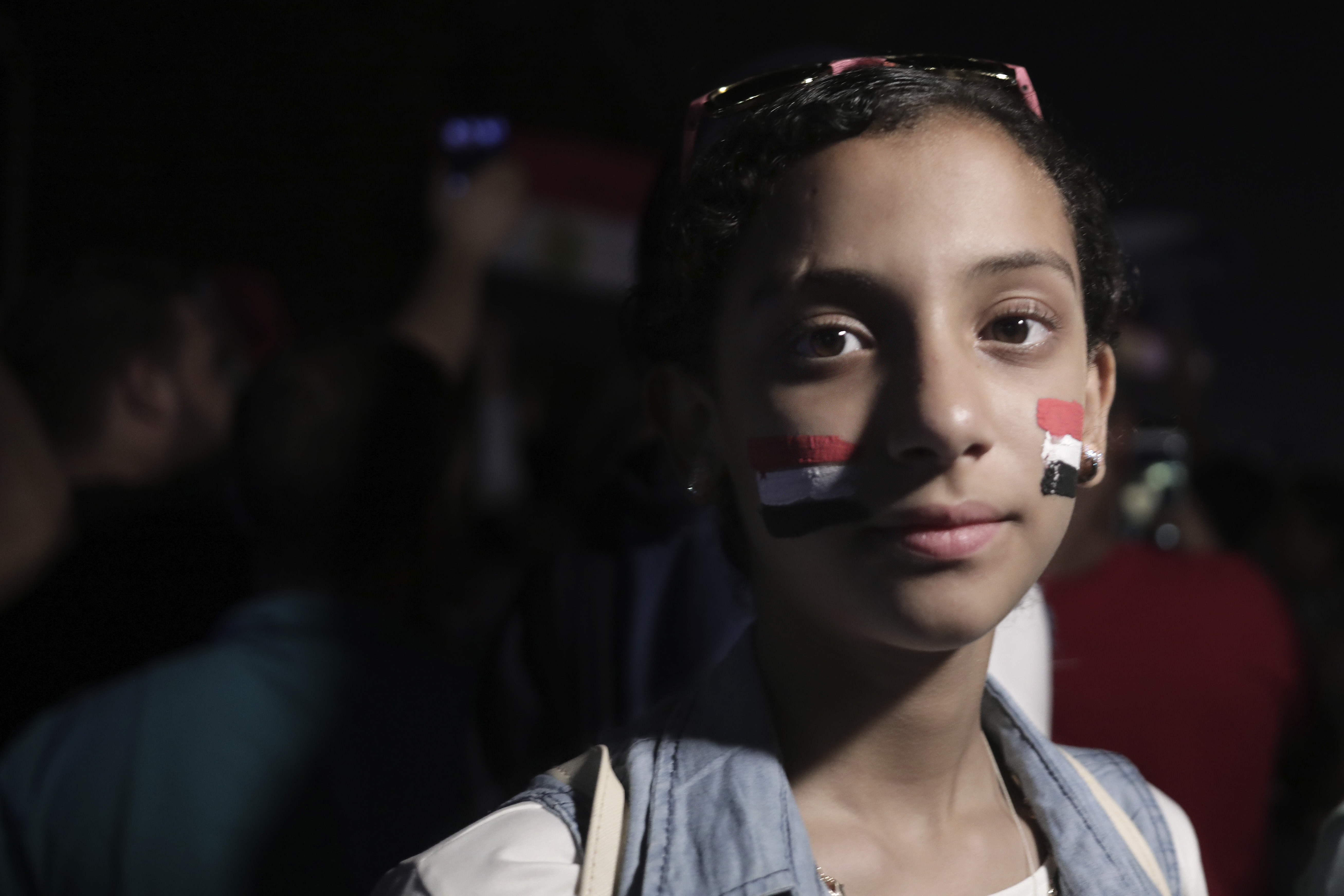 A soccer fan has Egyptian flags painted on her face as Egypt won a match against Zimbabwe during the Africa Cup of Nations, at a cafe in downtown in Cairo, Egypt, Friday, June 21, 2019. (AP Photo/Nariman El-Mofty)