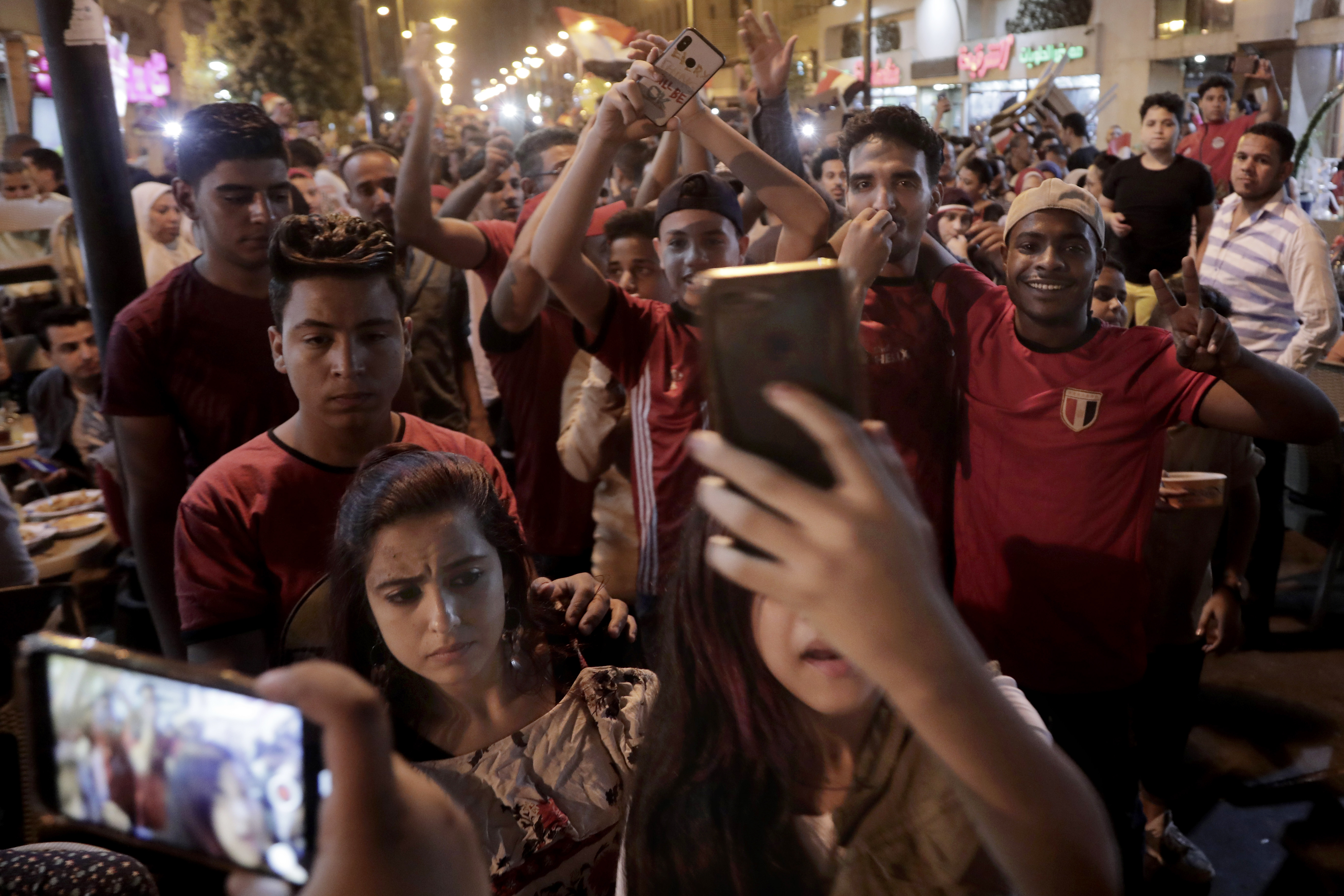 Egyptian soccer fans celebrate after their team won against Zimbabwe during the Africa Cup of Nations, on a street in Cairo, Egypt, Friday, June 21, 2019. (AP Photo/Nariman El-Mofty)