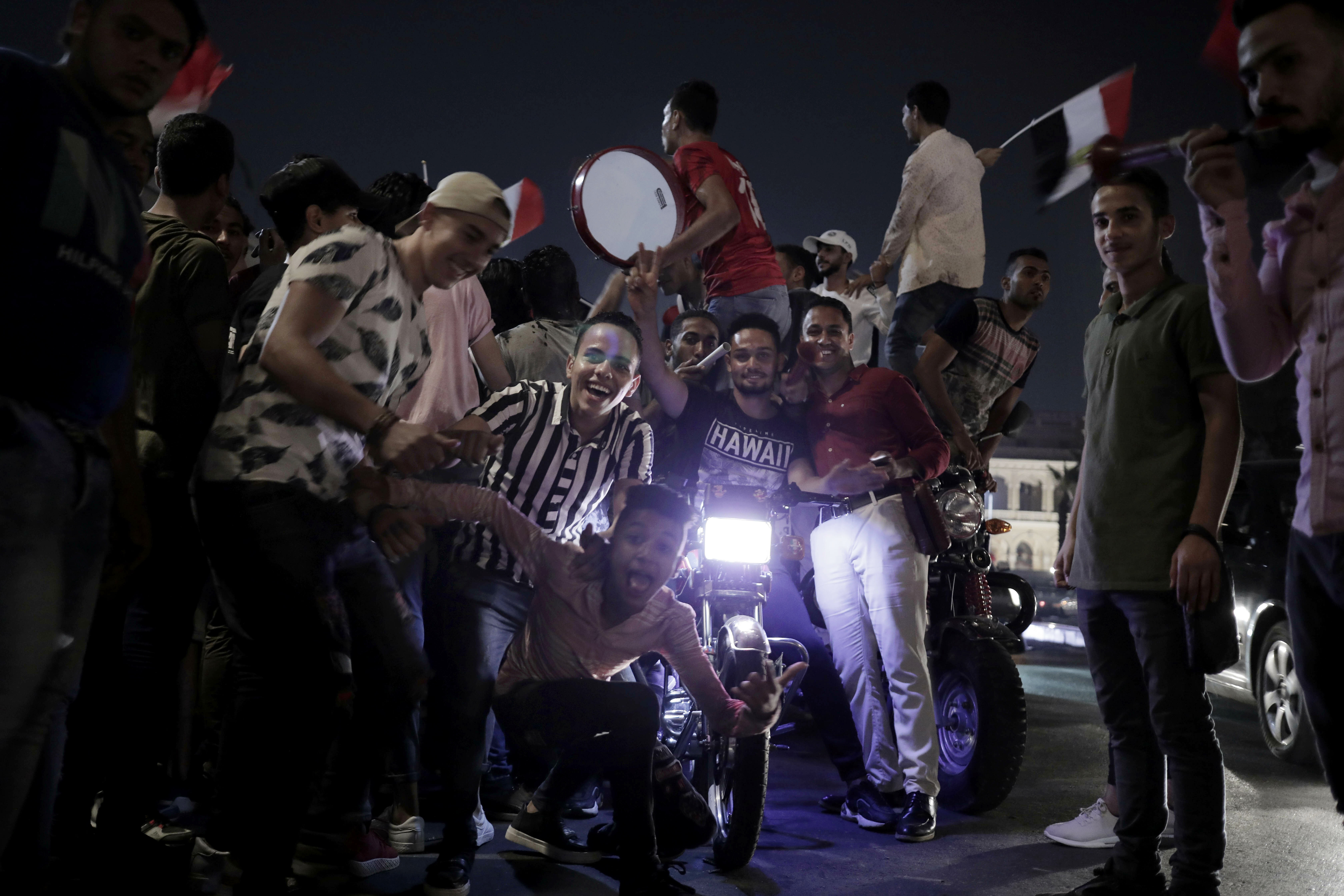 Egyptian soccer fans celebrate after their team won against Zimbabwe during the Africa Cup of Nations, on a street in Cairo, Egypt, Friday, June 21, 2019. (AP Photo/Nariman El-Mofty)