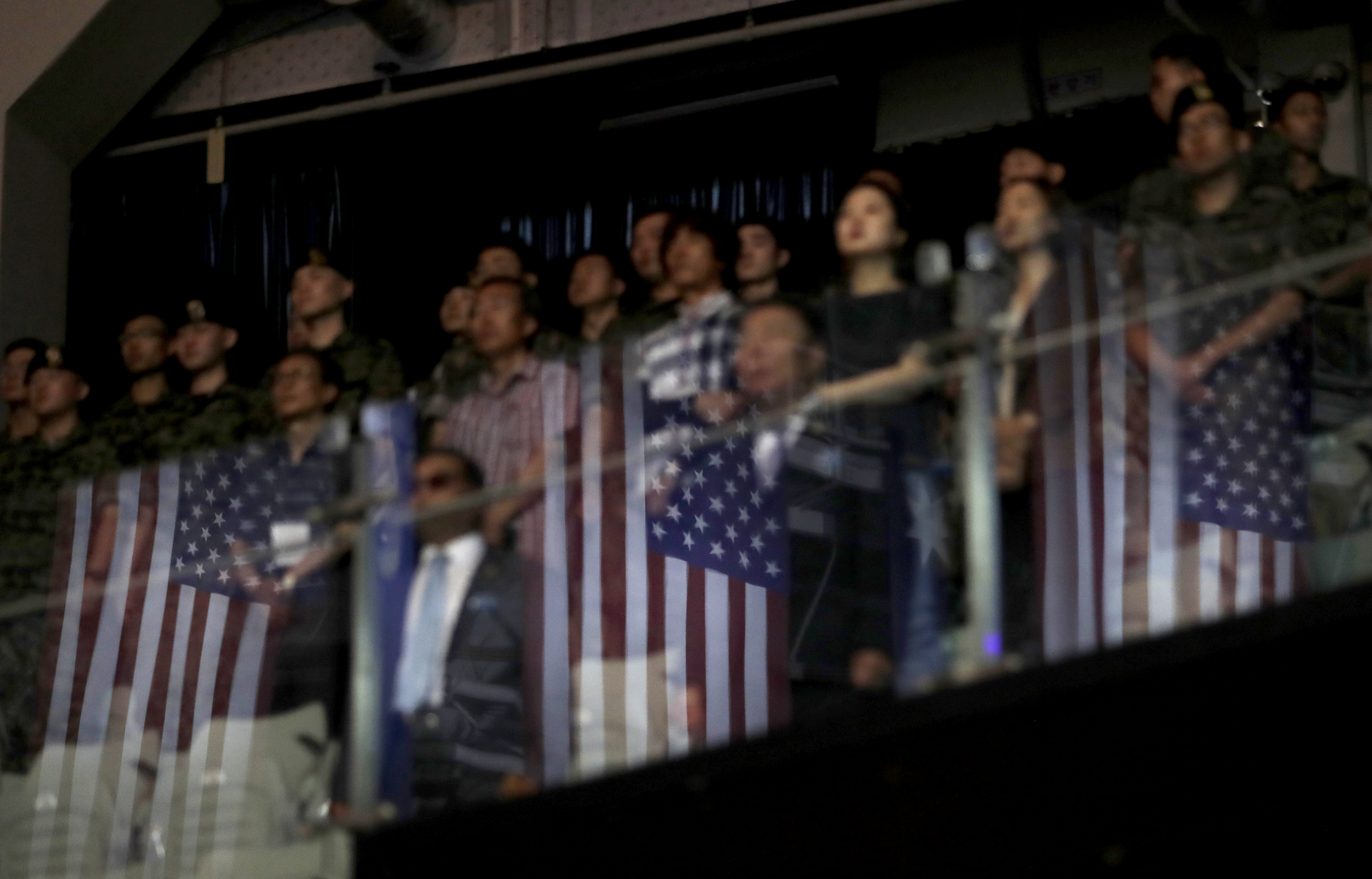 U.S. flags are reflected on the glass as participants stand during a ceremony to mark the 69th anniversary of the outbreak of the Korean War in Seoul, South Korea, Tuesday, June 25, 2019. South Korea and North Korea fought a devastating three-year war in the early 1950s that ended with an armistice, not a peace treaty. (AP Photo/Lee Jin-man)
