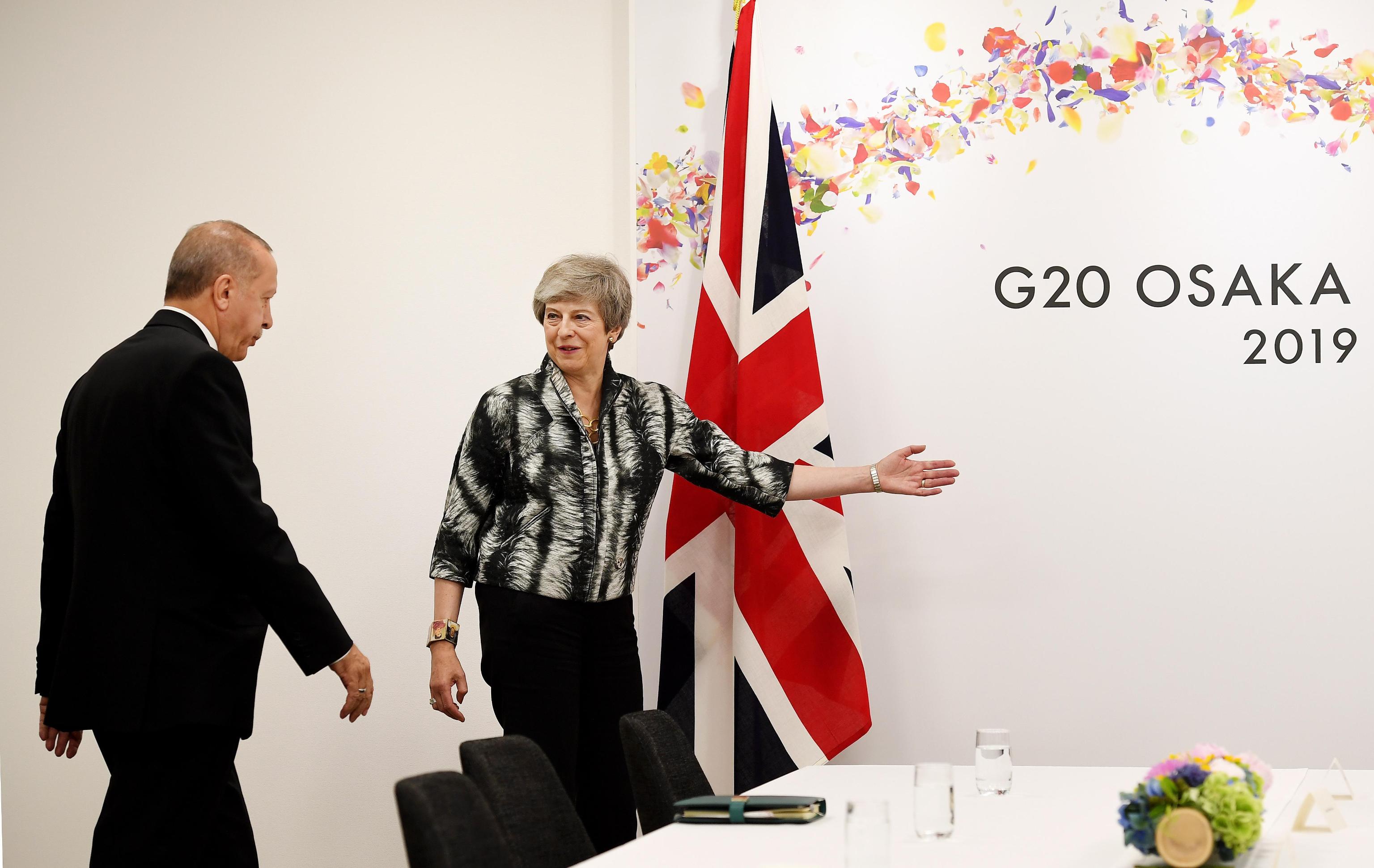 epa07681580 British Prime Minister Theresa May (R) gestures to Turkish President Recep Tayyip Erdogan (L) ahead of talks on the second day of the G20 Summit in Osaka, Japan, 29 June 2019. It is the first time that Japan hosts a G20 summit. The summit gathers leaders from 19 countries and the European Union to discuss topics such as global economy, trade and investment, innovation and employment.  EPA/ANDY RAIN / POOL