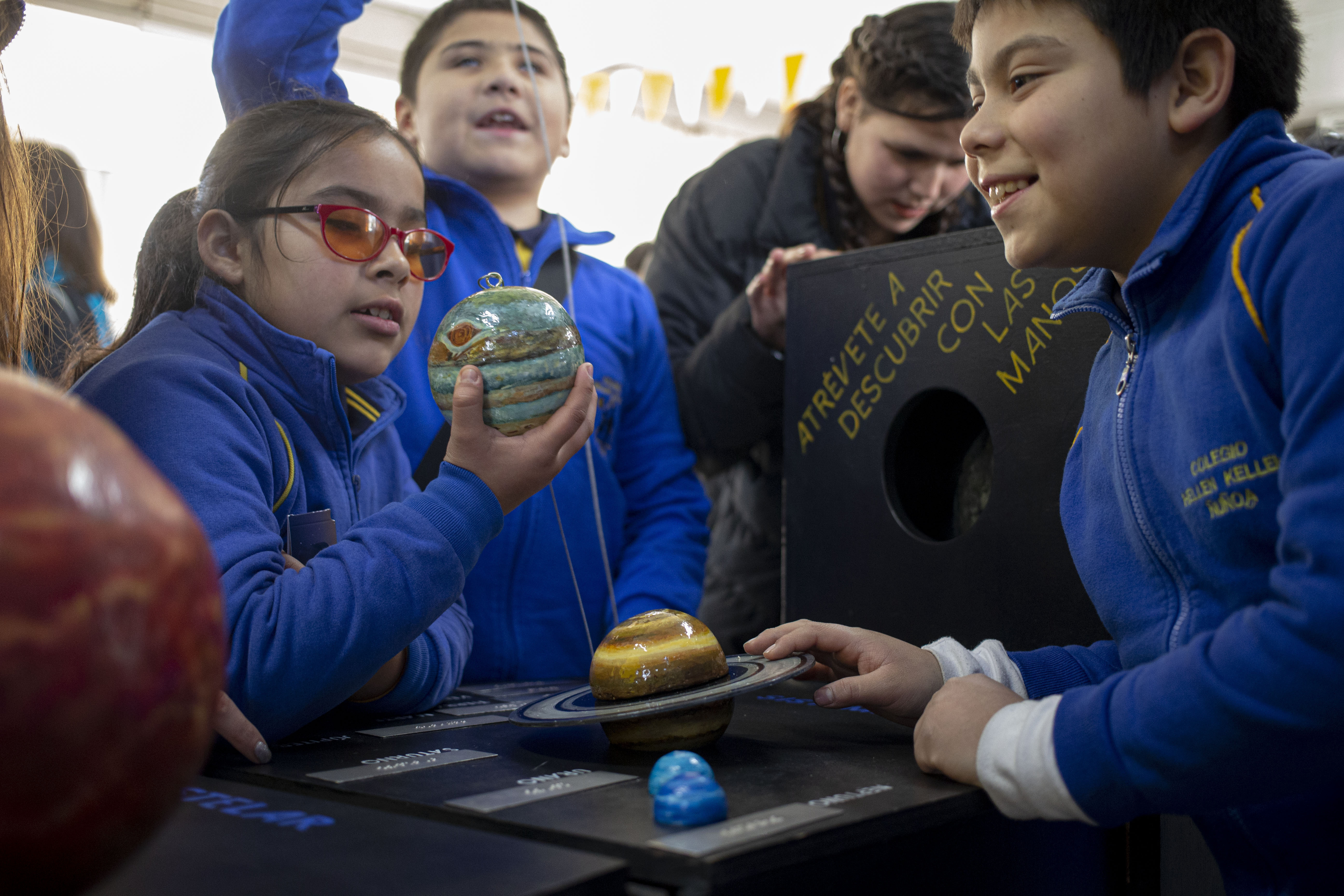 CORRECTS NAME OF UNIVERSITY - Blind school children take part in a sensorial experience with tools created by NASA and Edinboro University of Pennsylvania to experience an eclipse, during an event in the Helen Keller school in Santiago, Chile, Tuesday, June 25, 2019. The event comes exactly one week ahead of a total solar eclipse which is set to be fully visible in various South American countries, including Chile. (AP Photo/Esteban Felix)