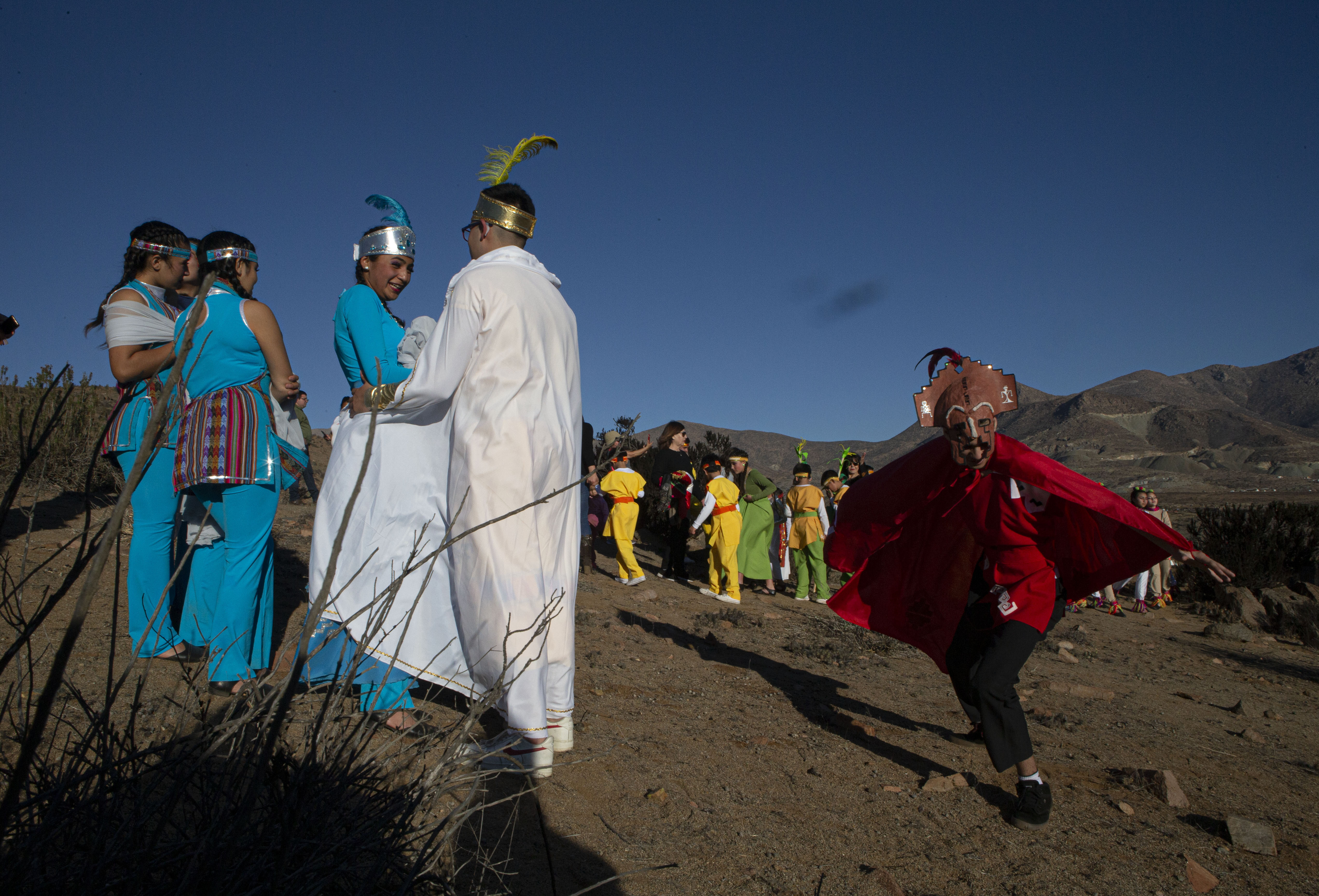 Youths dressed a Diaguitas indigenous people arrive to take part in a photo session before tomorrow's total solar eclipse in La Higuera, Chile, Monday, July 1, 2019. Tourists and scientists will gather in northern Chile, one of the best places in the world to watch the next the eclipse that will plunge parts of South America into darkness. (AP Photo/Esteban Felix)