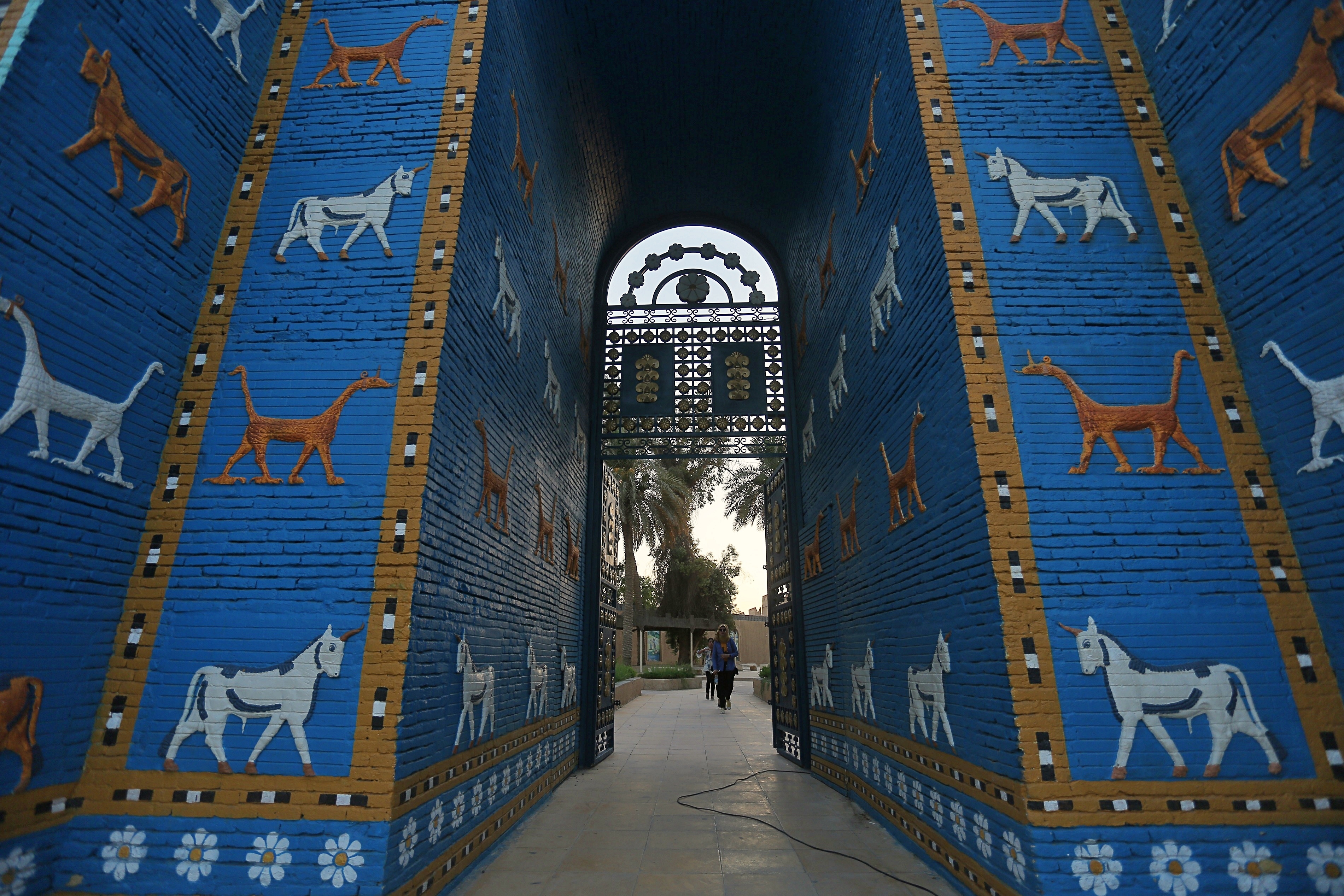 People walk near Ishtar Gate the archaeological site of Babylon, Iraq, Friday, July 5, 2019. Iraq on Friday celebrated the UNESCO World Heritage Committee's decision to name the historic city of Babylon a World Heritage Site in a vote held in Azerbaijan's capital, years after Baghdad began campaigning for the site to be added to the list. (AP Photo/Anmar Khalil)