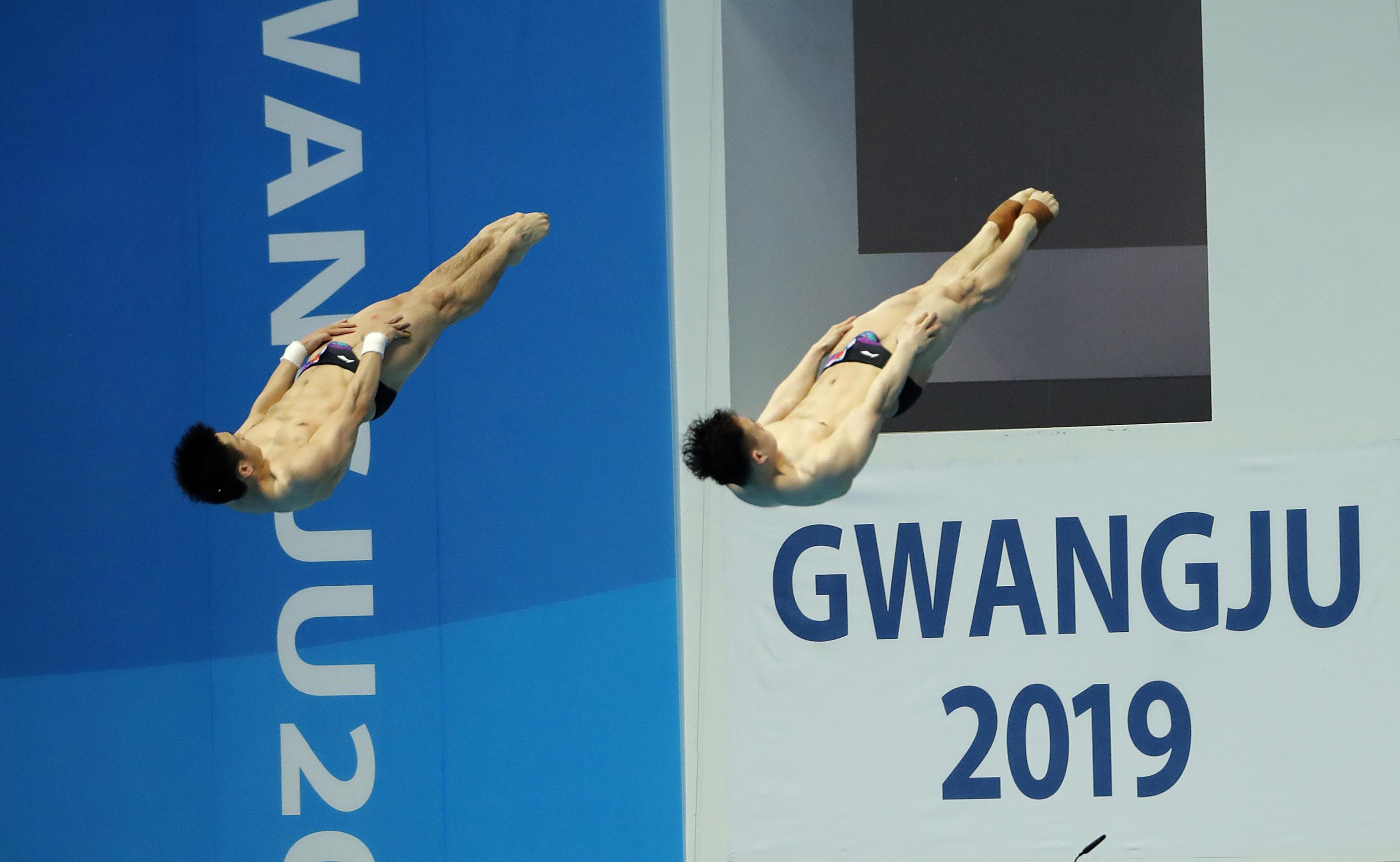 epa07713511 Yuan Can and Siyl Xie of China perform in Diving Men's 3 meters synchro Springboard of FINA Swimming World Championships 2019 in Gwangju, South Korea, 13 July 2019.  EPA/ANTONIO BAT