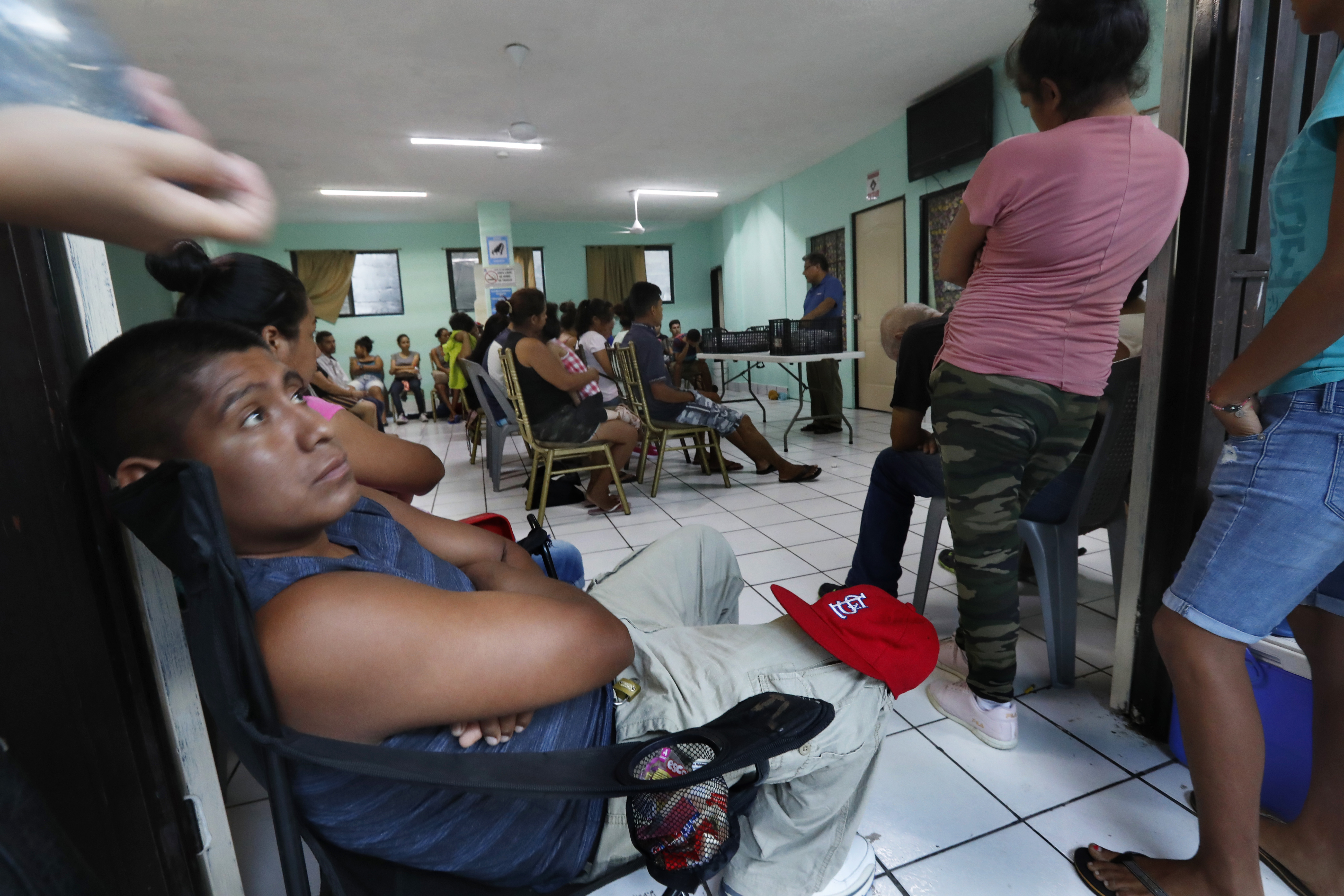 Pastor Aaron Mendes speaks to migrants staying at his AMAR migrant shelter in Nuevo Laredo, Mexico, Wednesday, July 17, 2019. Asylum-seekers grappled to understand what a new U.S. policy that all but eliminates refugee claims by Central Americans and many others meant for their bids to find a better life in America amid a chaos of rumors, confusion and fear. (AP Photo/Marco Ugarte)