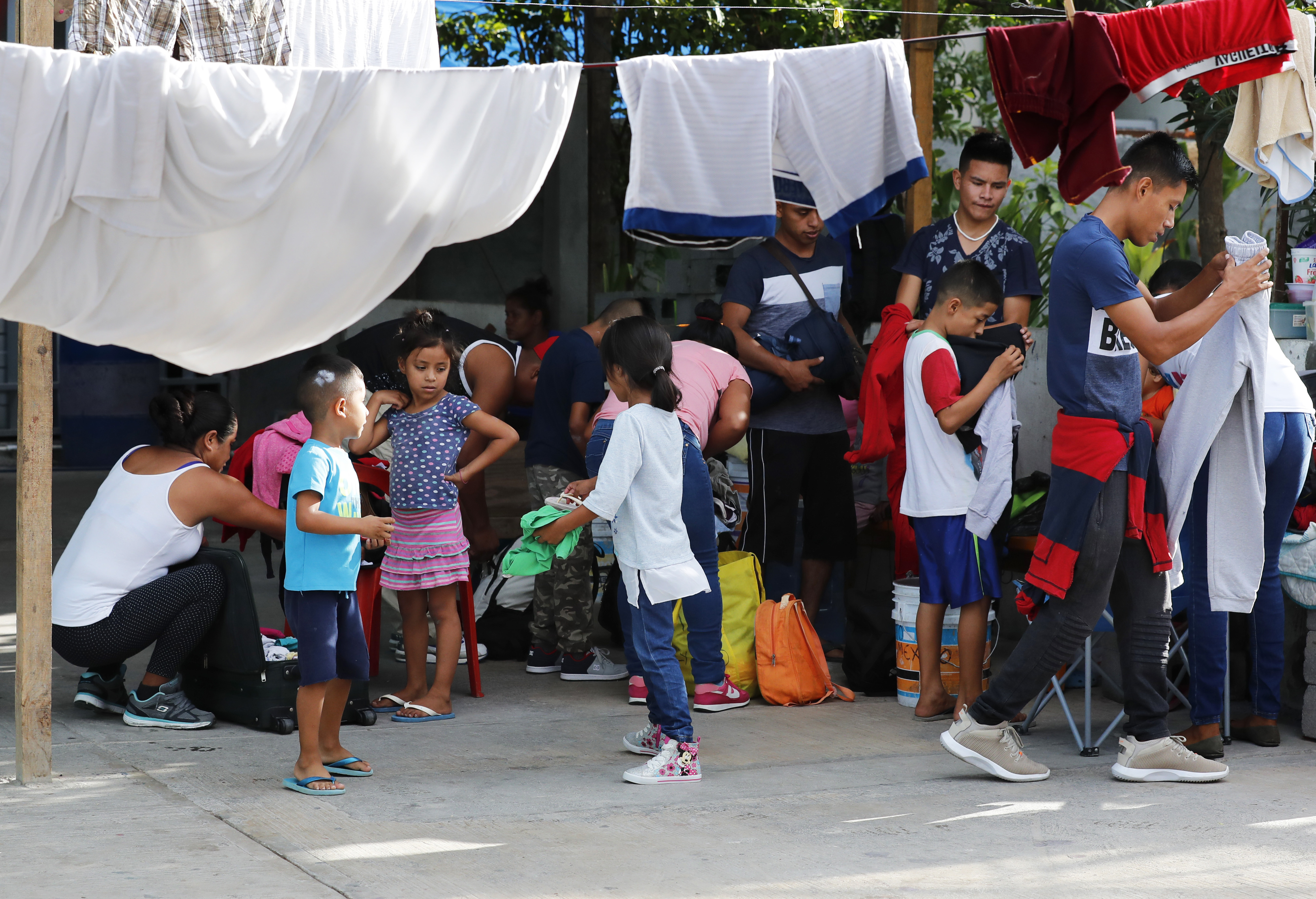 Migrants pack their bags as they wait to be taken to the U.S. border to apply for asylum, at the AMAR migrant shelter in Nuevo Laredo, Mexico, Wednesday, July 17, 2019. Asylum-seekers grappled to understand what a new U.S. policy that all but eliminates refugee claims by Central Americans and many others meant for their bids to find a better life in America amid a chaos of rumors, confusion and fear. (AP Photo/Marco Ugarte)