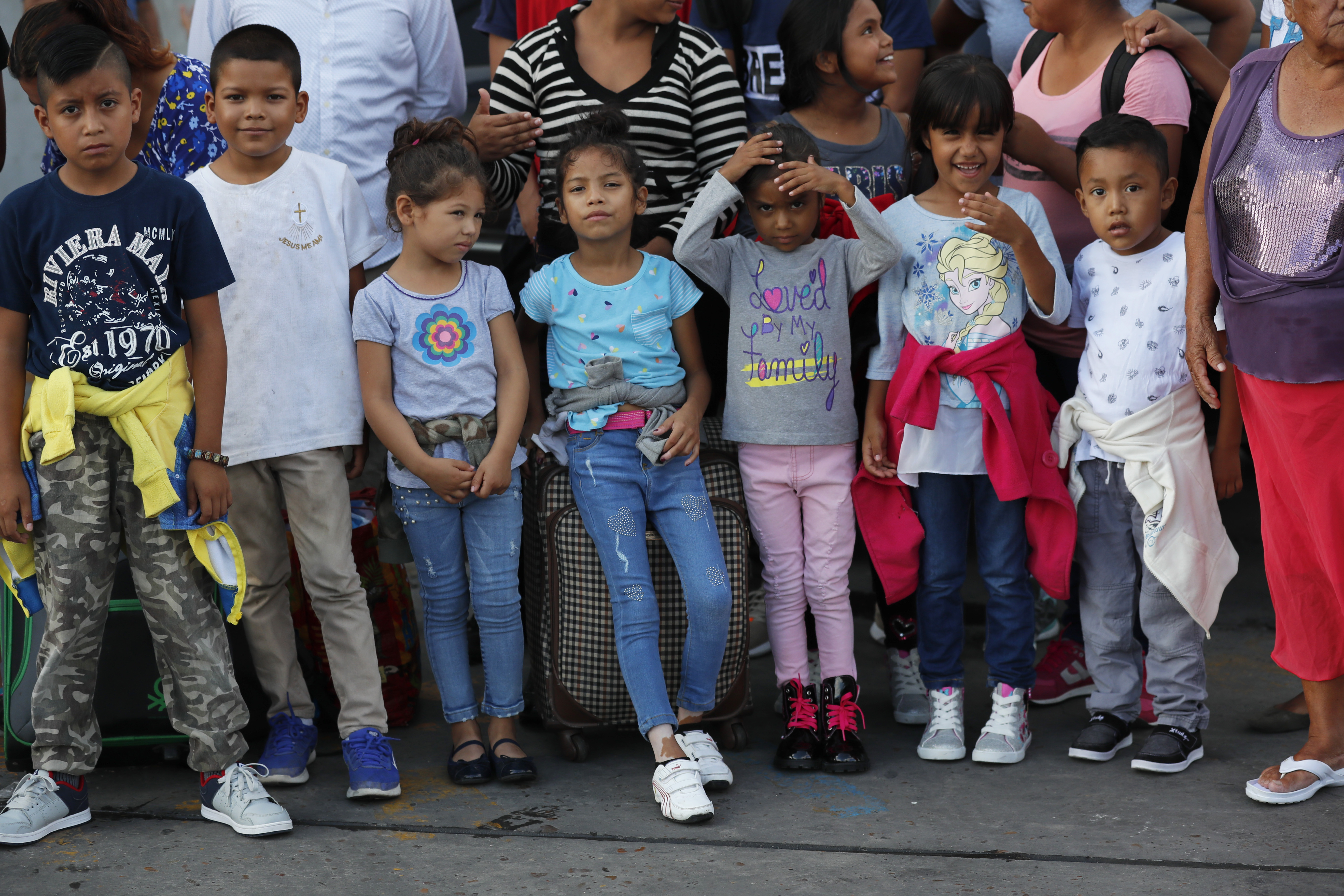Migrant children and their families who were lodging at the AMAR migrant shelter, get off the Pastor's vehicle to go to the Mexican immigration office on International Bridge 1, before being taken to apply for asylum on the United States side, in Nuevo Laredo, Mexico, Wednesday, July 17, 2019. Asylum-seekers grappled to understand what a new U.S. policy that all but eliminates refugee claims by Central Americans and many others meant for their bids to find a better life in America amid a chaos of rumors, confusion and fear. (AP Photo/Marco Ugarte)