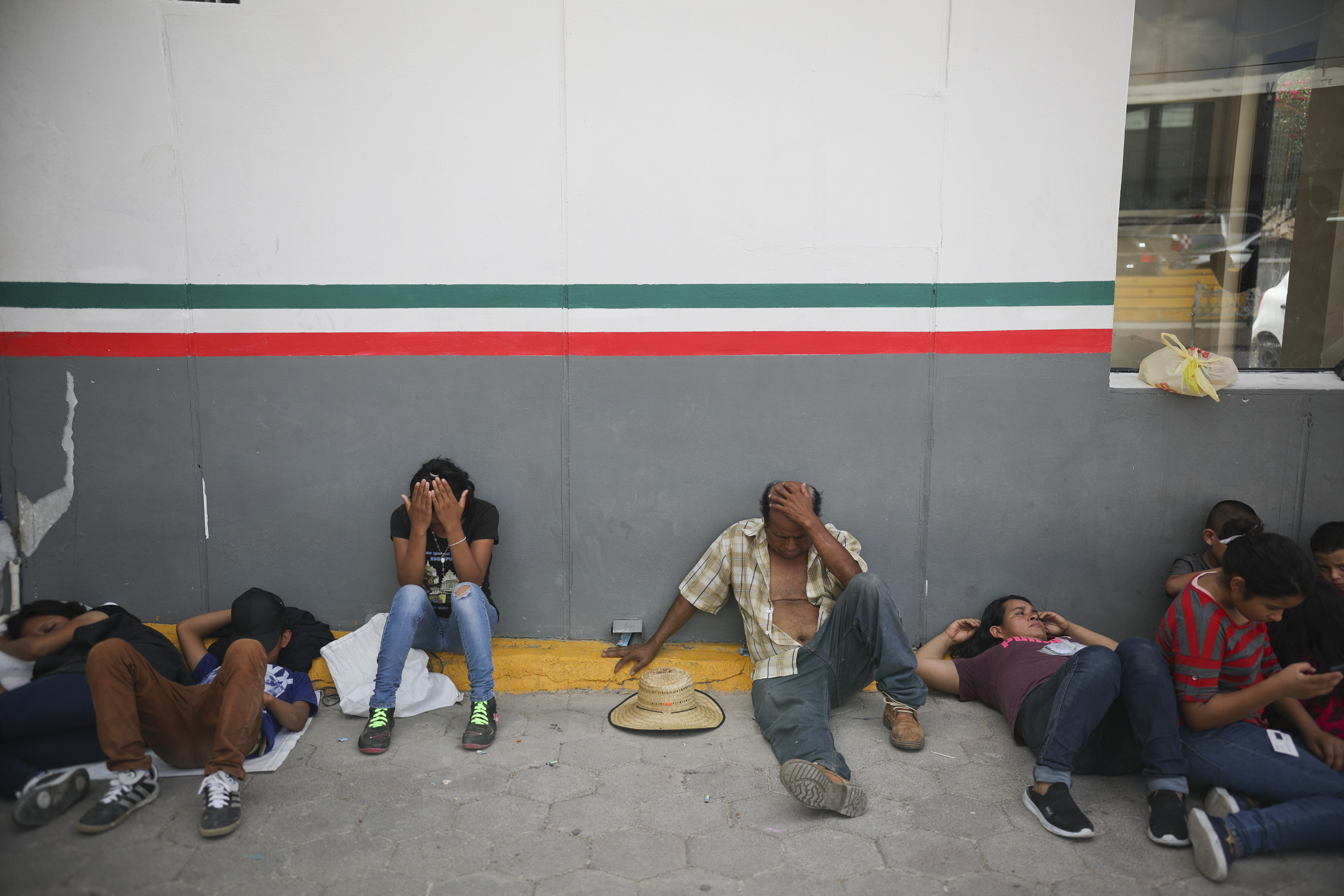 Migrants rest near a Mexican immigration center where people have set up a camp to sleep in Matamoros, Mexico, Thursday, Aug. 1, 2019, on the border with Brownsville, Texas. The United States government has sent some 800 mostly Central American and Cuban immigrants back to this northern Mexico border city since expanding its controversial plan to this easternmost point on the shared border two weeks ago, according to local Mexican authorities. (AP Photo/Emilio Espejel)