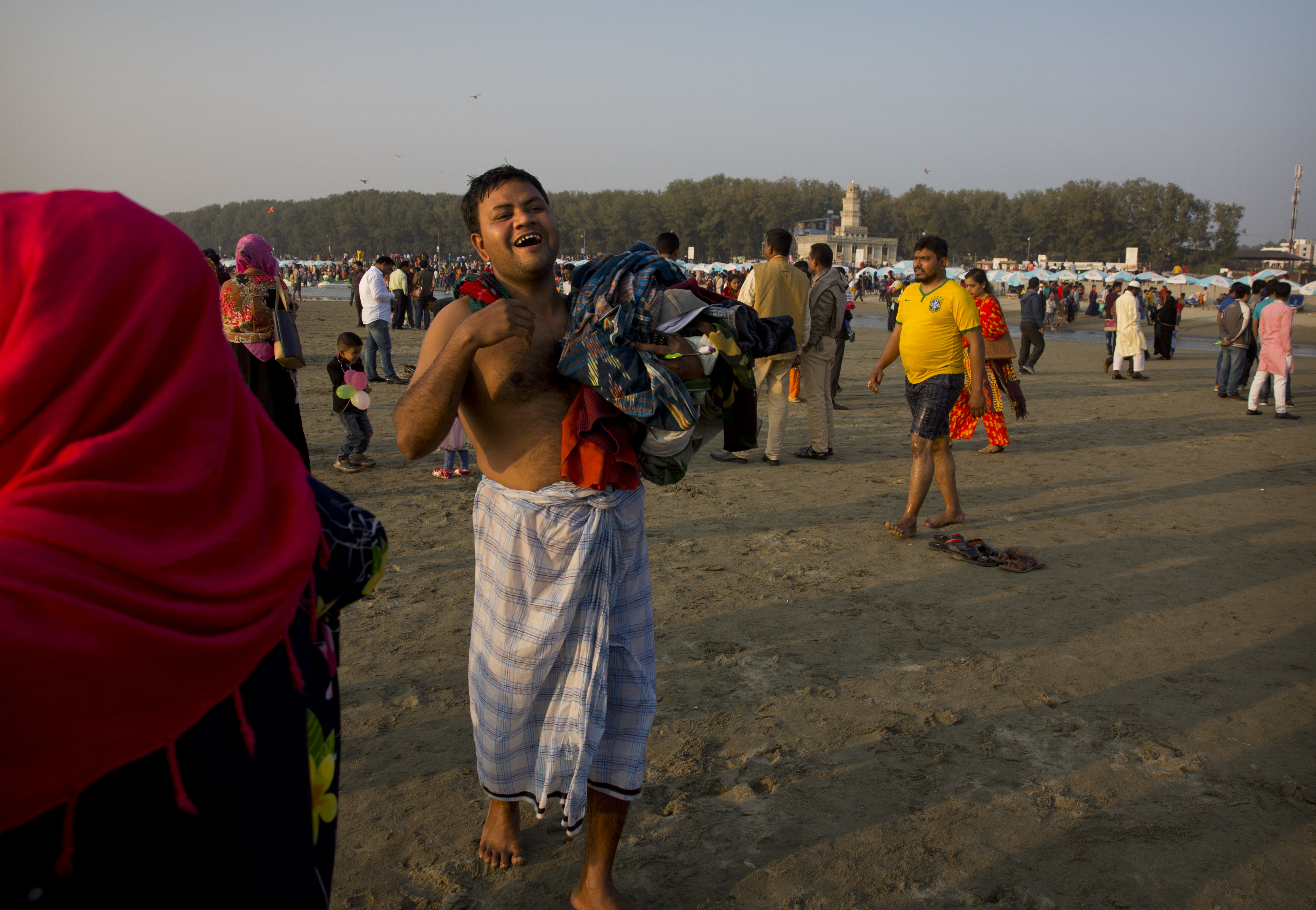 A Bangladeshi man calls his friends after swimming at a beach on a weekly holiday in Cox's Bazar, Bangladesh, Friday, Jan. 26, 2018. Miles-long beaches makes this coastal district Bangladesh's top tourist destination. (AP Photo/Manish Swarup)