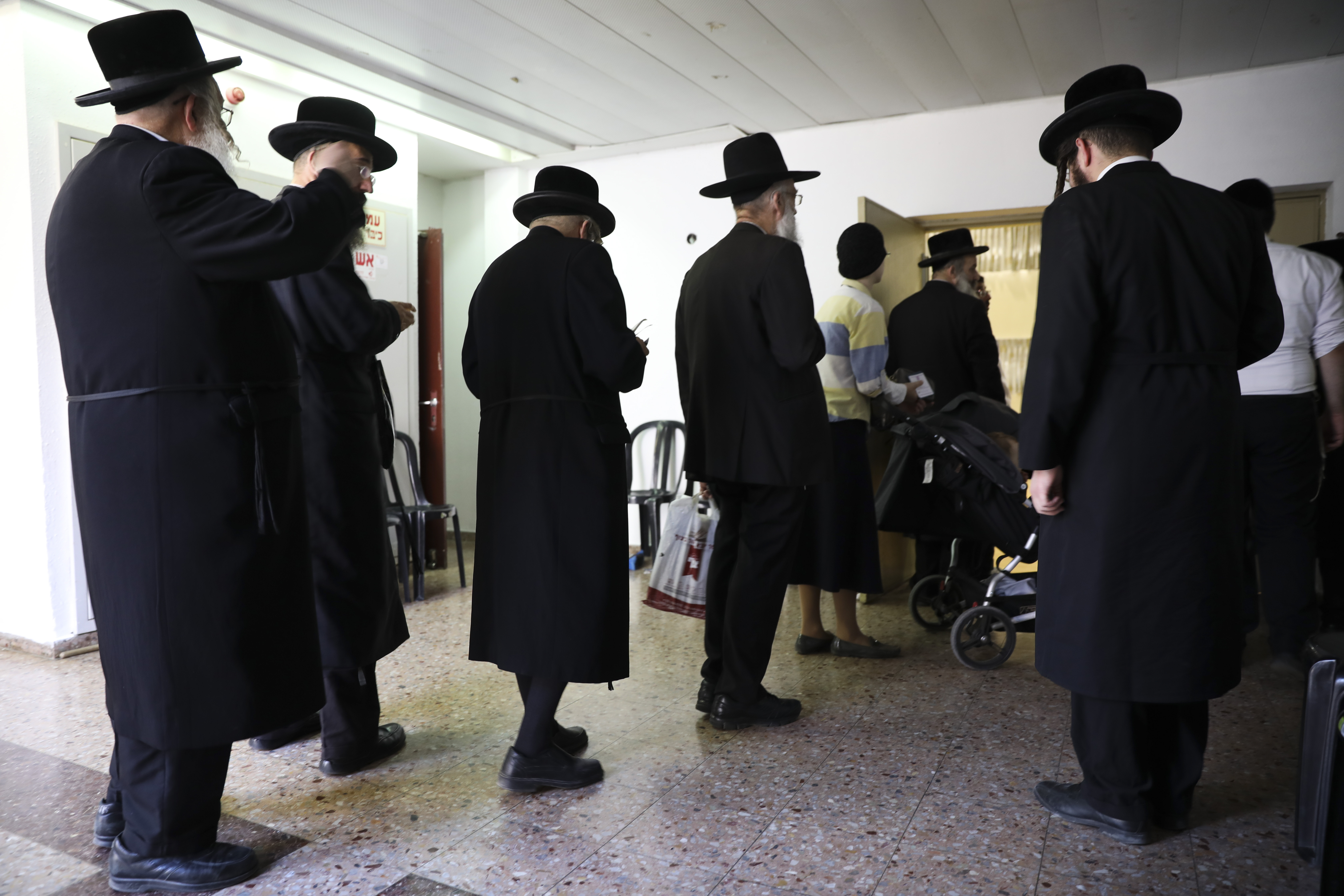 Ultra orthodox Jews line up to vote in Bnei Brak, Israel, Tuesday, Sept. 17, 2019. Israelis began voting Tuesday in an unprecedented repeat election that will decide whether longtime Prime Minister Benjamin Netanyahu stays in power despite a looming indictment on corruption charges. (AP Photo/Oded Balilty)