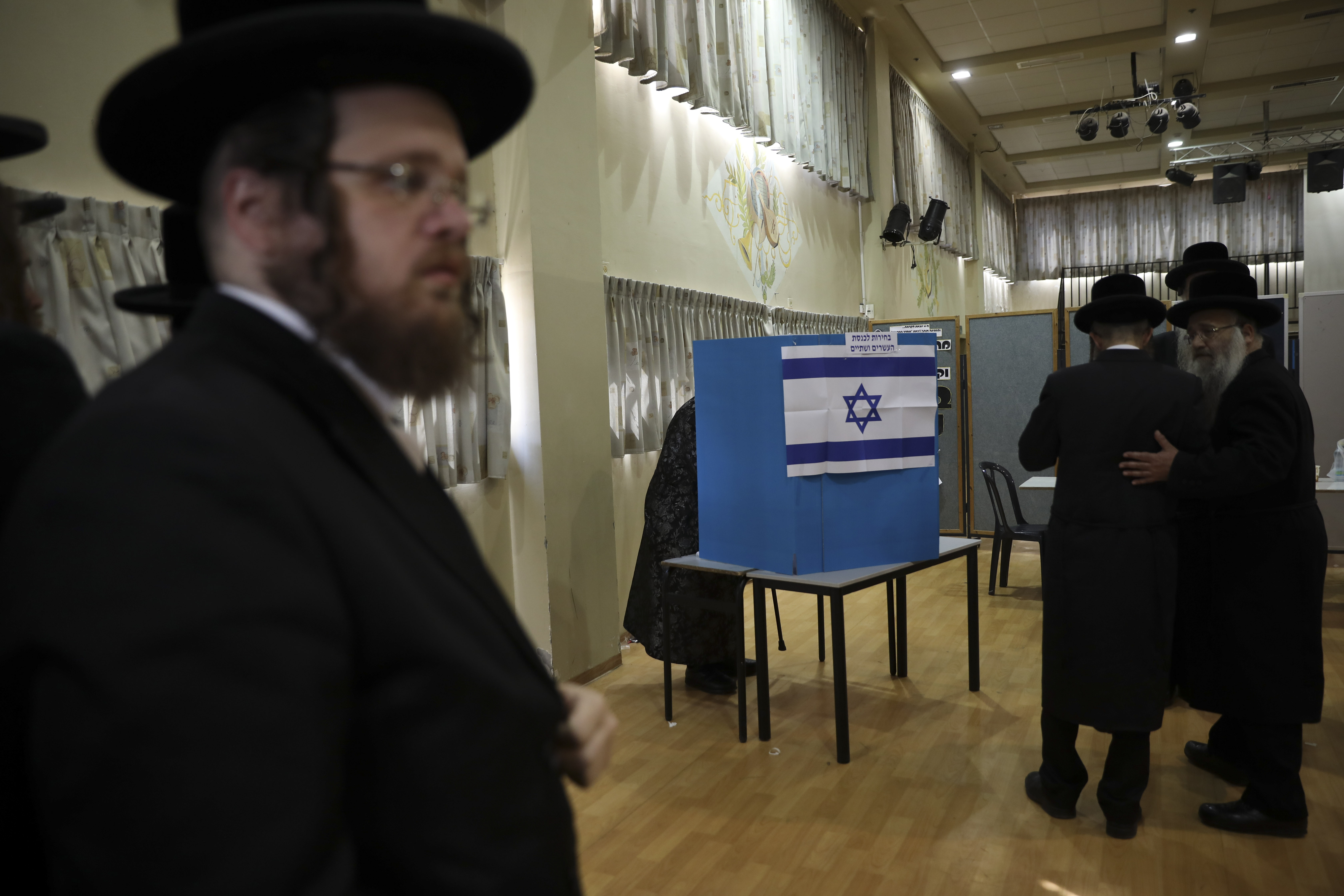 Ultra orthodox Jews wait for Rabbi Israel Hager to vote in Bnei Brak, Israel, Tuesday, Sept. 17, 2019. Israelis began voting Tuesday in an unprecedented repeat election that will decide whether longtime Prime Minister Benjamin Netanyahu stays in power despite a looming indictment on corruption charges. (AP Photo/Oded Balilty)