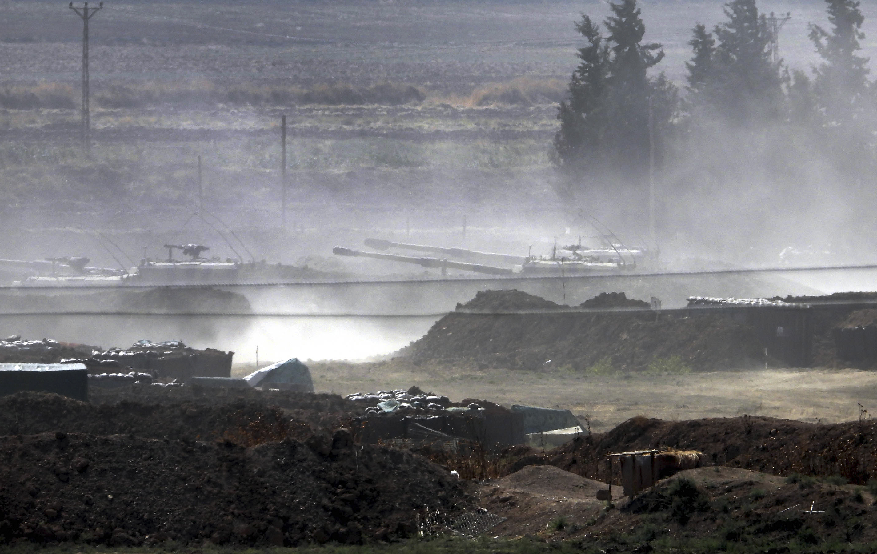 In this Sunday, Oct. 6, 2019 photo, Turkish forces artillery pieces are driven to their new positions near the border with Syria in Sanliurfa province, Turkey. U.S.-backed Kurdish-led forces in Syria said American troops began withdrawing Monday from their positions along Turkey's border in northeastern Syria, ahead of an anticipated Turkish invasion that the Kurds say will overturn five years of achievements in the battle against the Islamic State group. (DHA via AP)