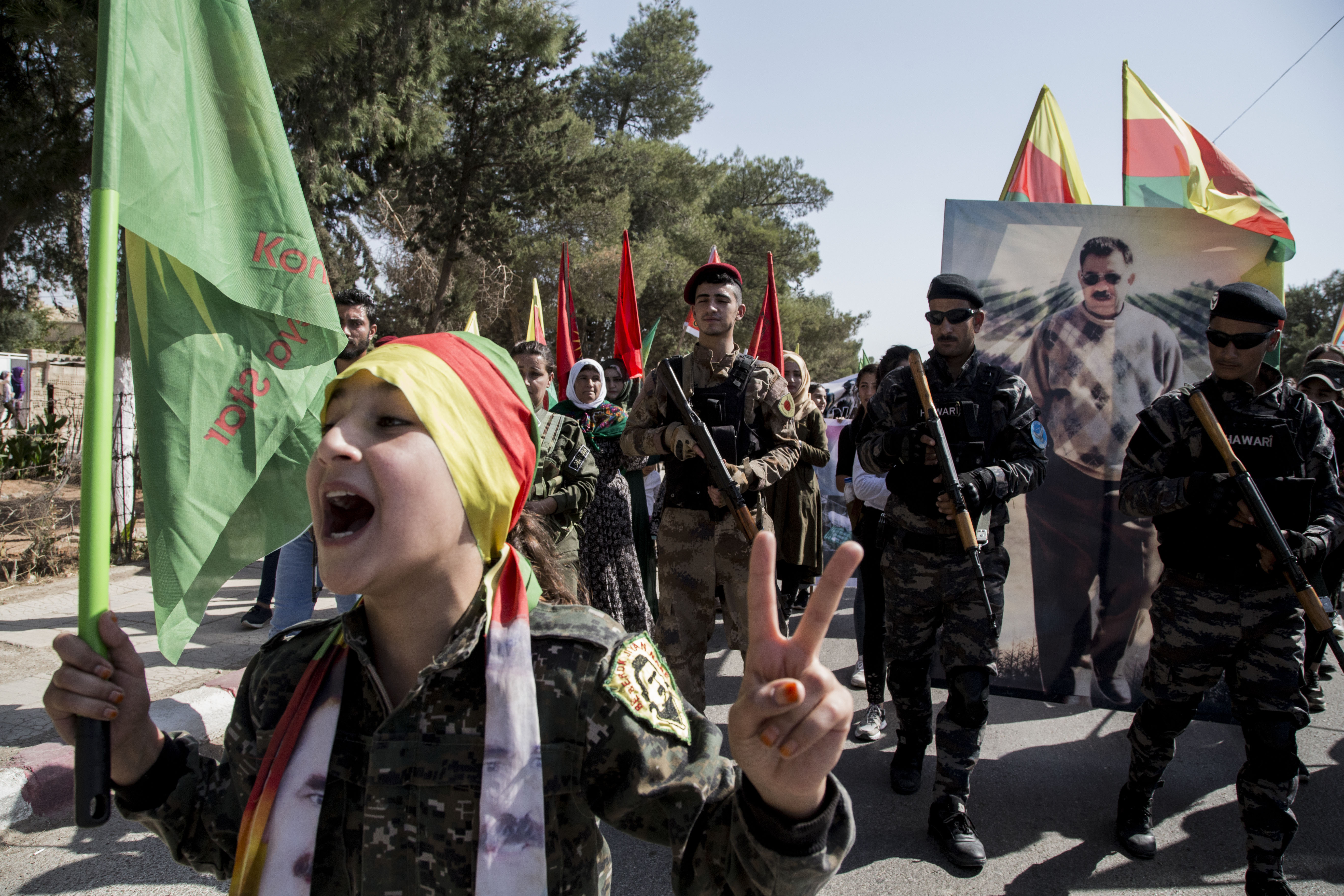 Fighters of the Syrian Democratic Forces, SDF, march during a demonstration against possible Turkish military operation in their areas in Al-Qahtaniya, Syria, Monday, Oct. 7, 2019. Syria's Kurds accused the U.S. of turning its back on its allies and risking gains made in the fight against the Islamic State group as American troops began pulling back on Monday from positions in northeastern Syria ahead of an expected Turkish assault. (AP Photo/Baderkhan Ahmad)