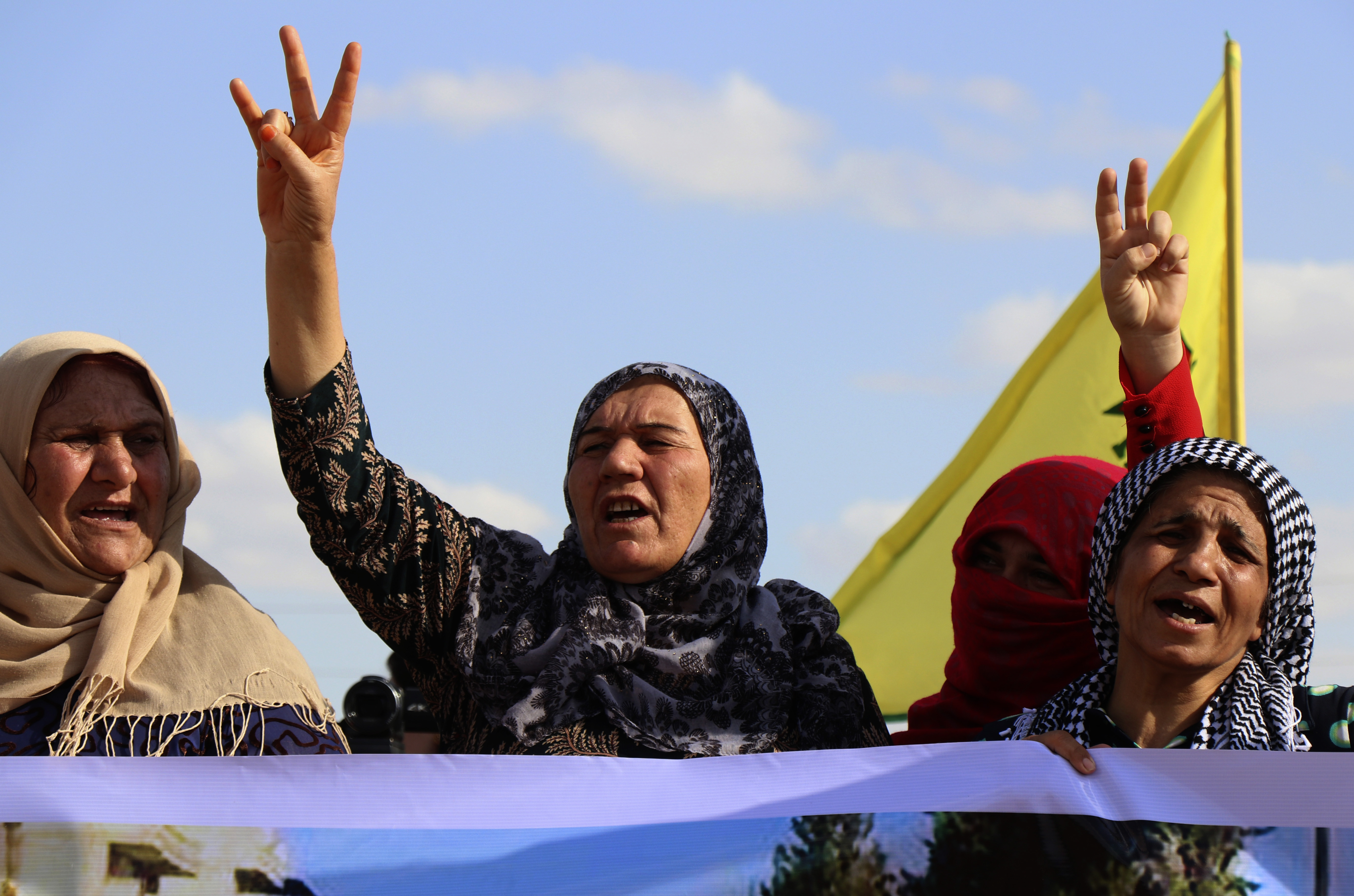 Kurdish women flash victory signs and shout slogans as they protest against possible Turkish military operation on their areas, at the Syrian-Turkish border, in Ras al-Ayn, Syria, Monday, Oct. 7, 2019. Syria's Kurds accused the U.S. of turning its back on its allies and risking gains made in the fight against the Islamic State group as American troops began pulling back on Monday from positions in northeastern Syria ahead of an expected Turkish assault. (AP Photo)