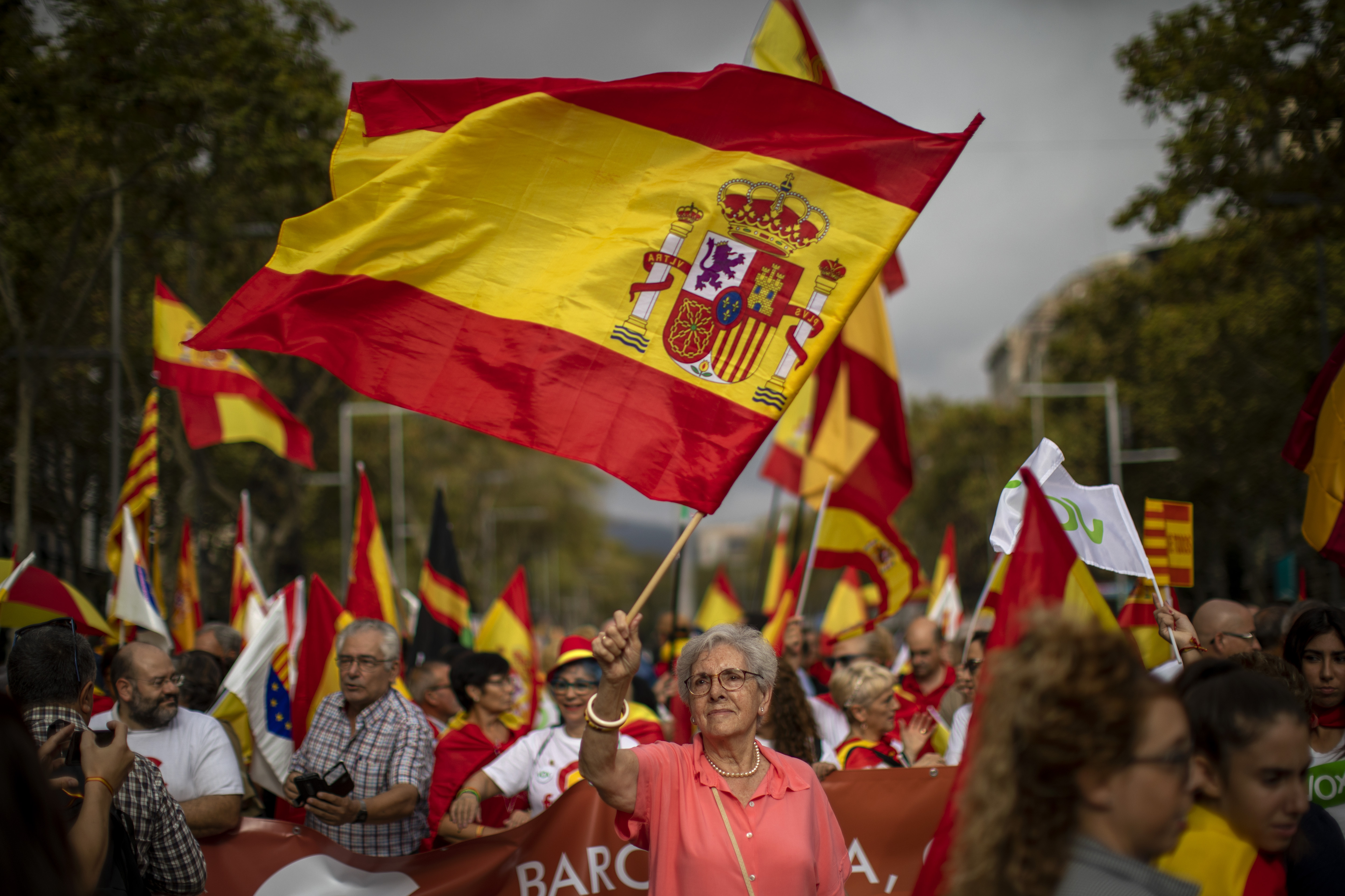 People wave Spanish flags as they celebrate a holiday known as 