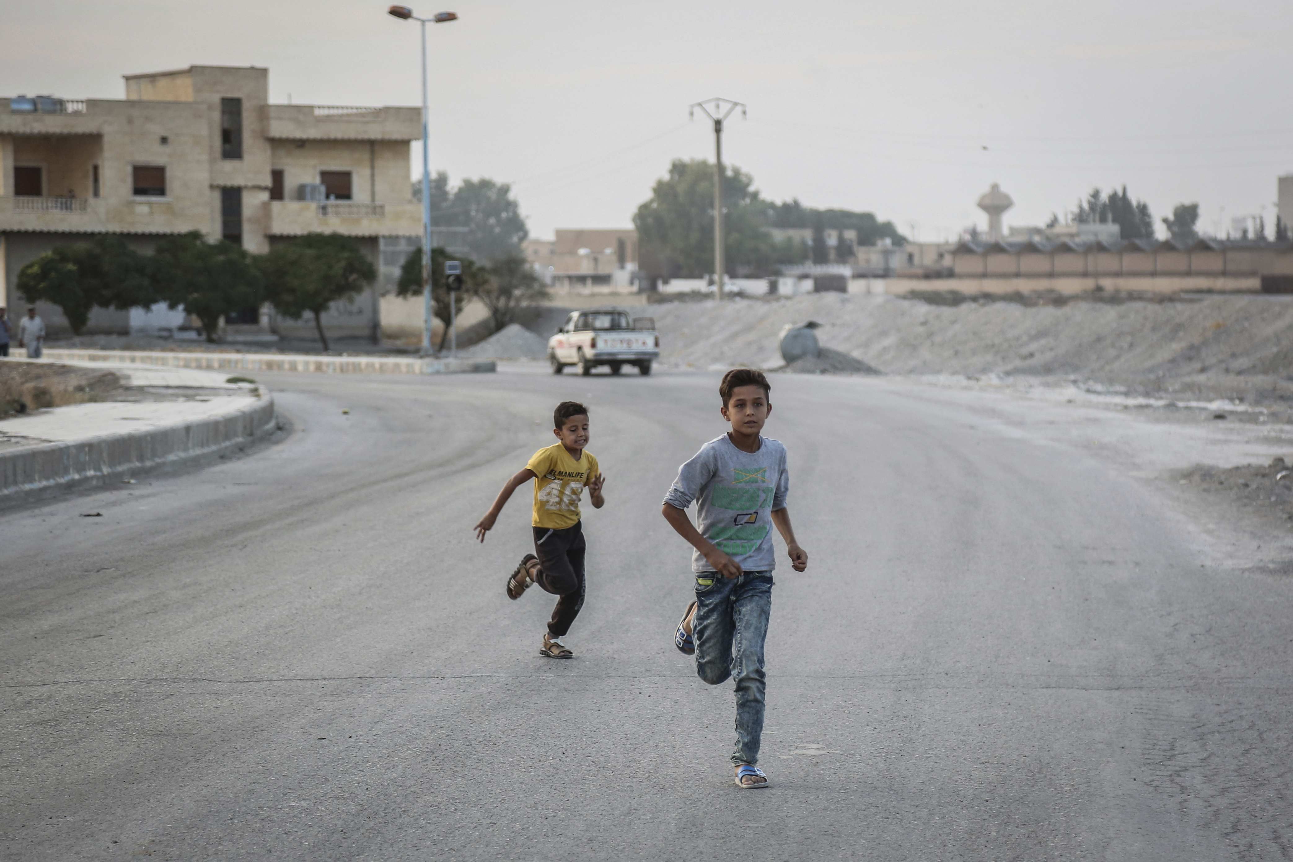 14 October 2019, Syria, Tell Abiad: Two young boys run on a deserted street. Photo by: Anas Alkharboutli/picture-alliance/dpa/AP Images
