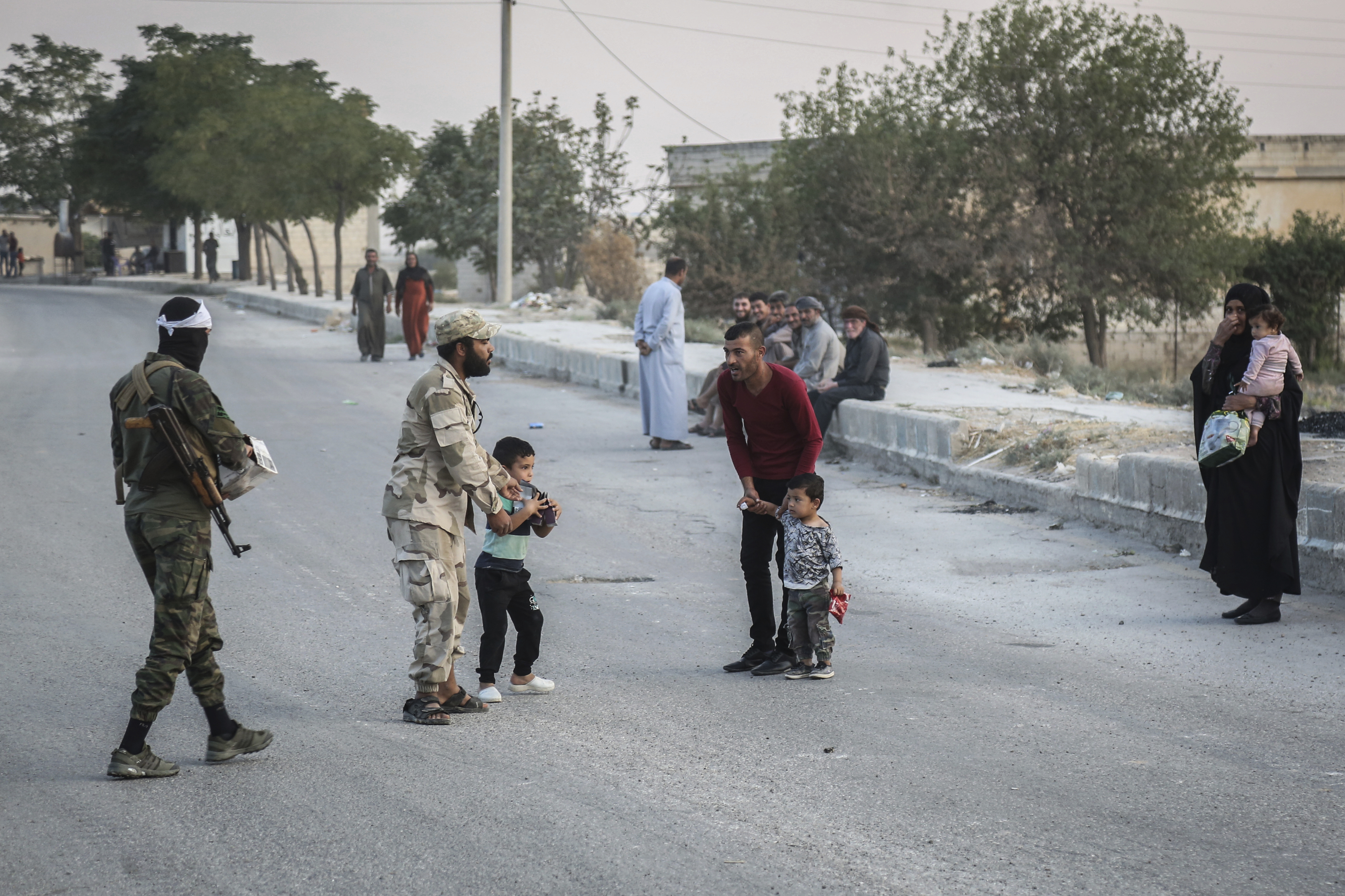 14 October 2019, Syria, Tell Abiad: Soldiers of the Turkish-backed Syrian National Army talk to local residents. Photo by: Anas Alkharboutli/picture-alliance/dpa/AP Images