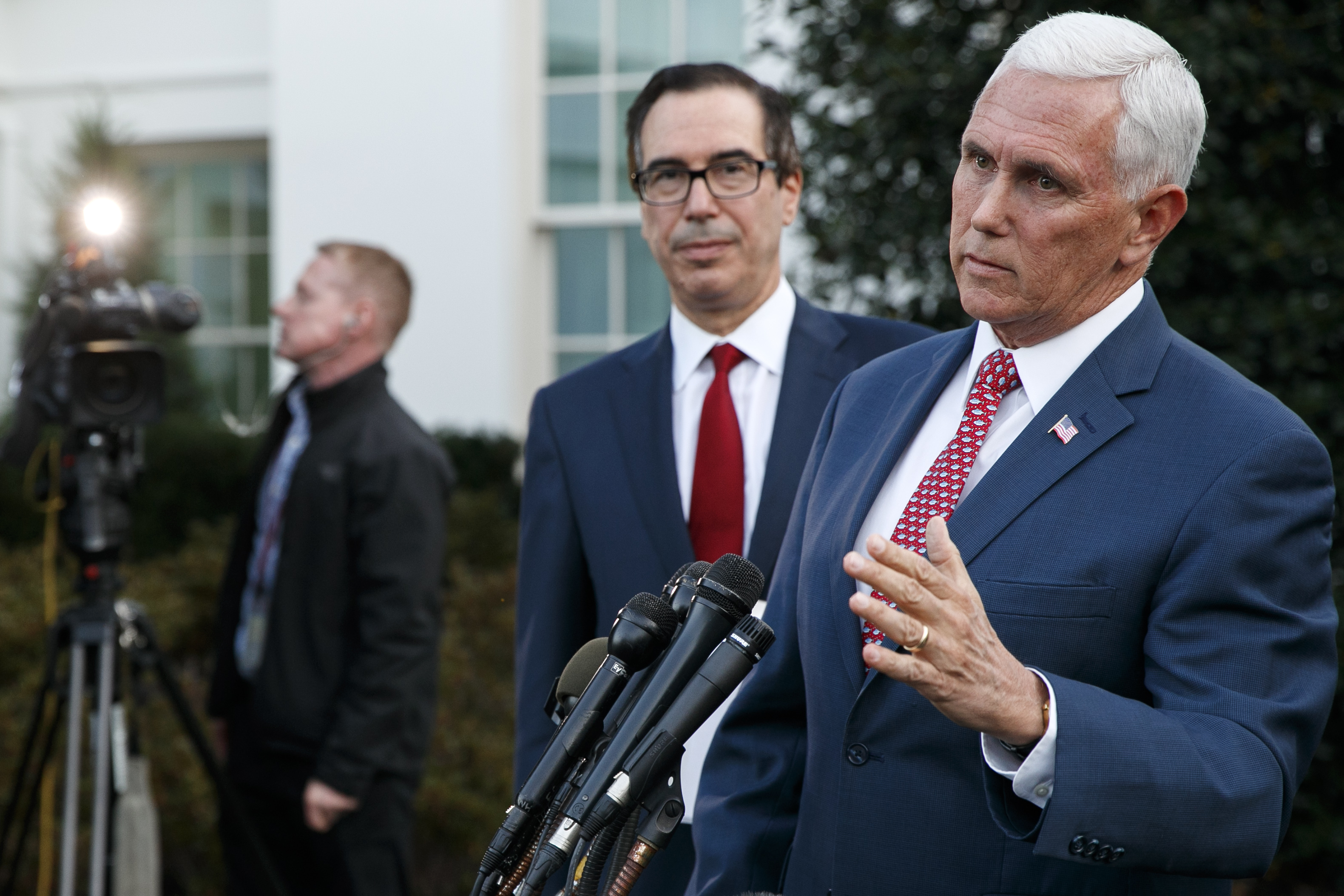 Vice President Mike Pence, with Treasury Secretary Steven Mnuchin, speaks to reporters outside the West Wing of the White House, Monday, Oct. 14, 2019, in Washington. The U.S. is calling for an immediate ceasefire in Turkey's strikes against Kurds in Syria, and is sending Pence to lead mediation effort (AP Photo/Jacquelyn Martin)