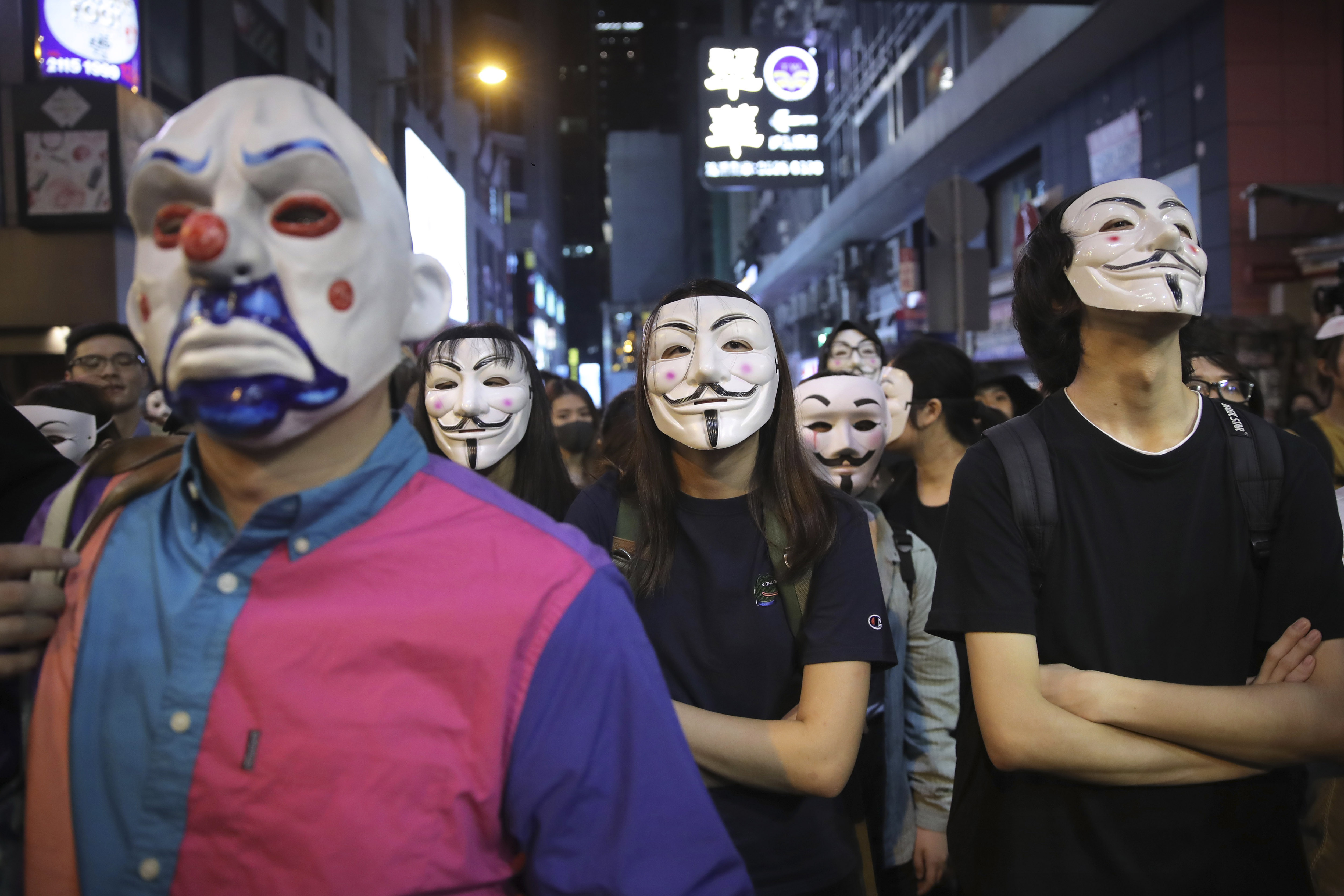 People in Guy Fawkes masks gather on a street in Hong Kong, Thursday, Oct. 31, 2019. Hong Kong authorities are bracing as pro-democracy protesters urged people on Thursday to celebrate Halloween by wearing masks on a march in defiance of a government ban on face coverings. (AP Photo/Kin Cheung)