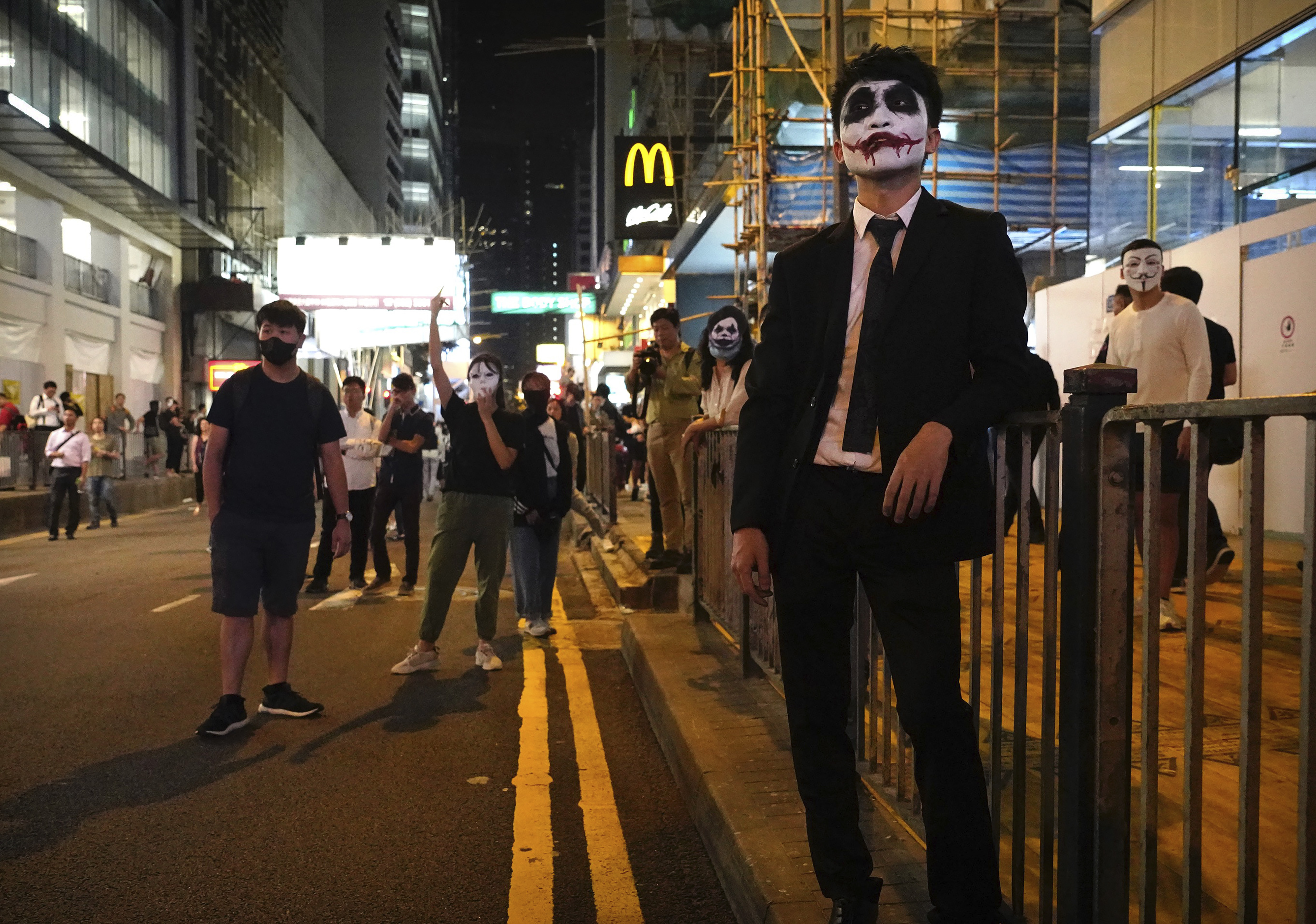 People wearing masks and face paint gather along a street in Hong Kong, Thursday, Oct. 31, 2019. Hong Kong authorities are bracing as pro-democracy protesters urged people on Thursday to celebrate Halloween by wearing masks on a march in defiance of a government ban on face coverings. (AP Photo/Vincent Yu)
