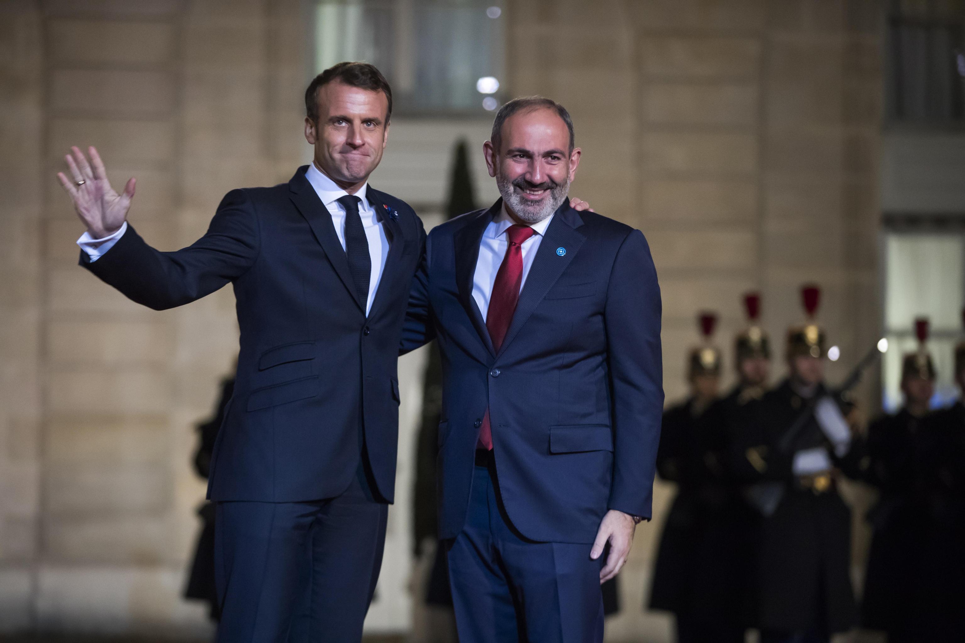 epa07989398 French President Emmanuel Macron (L) welcomes Armenian Prime Minister Nikol Pashinyan (R)  for a dinner held with participants of the Paris Peace Forum, at the Elysee Palace, in Paris, France, 11 November 2019.  EPA/CHRISTOPHE PETIT TESSON