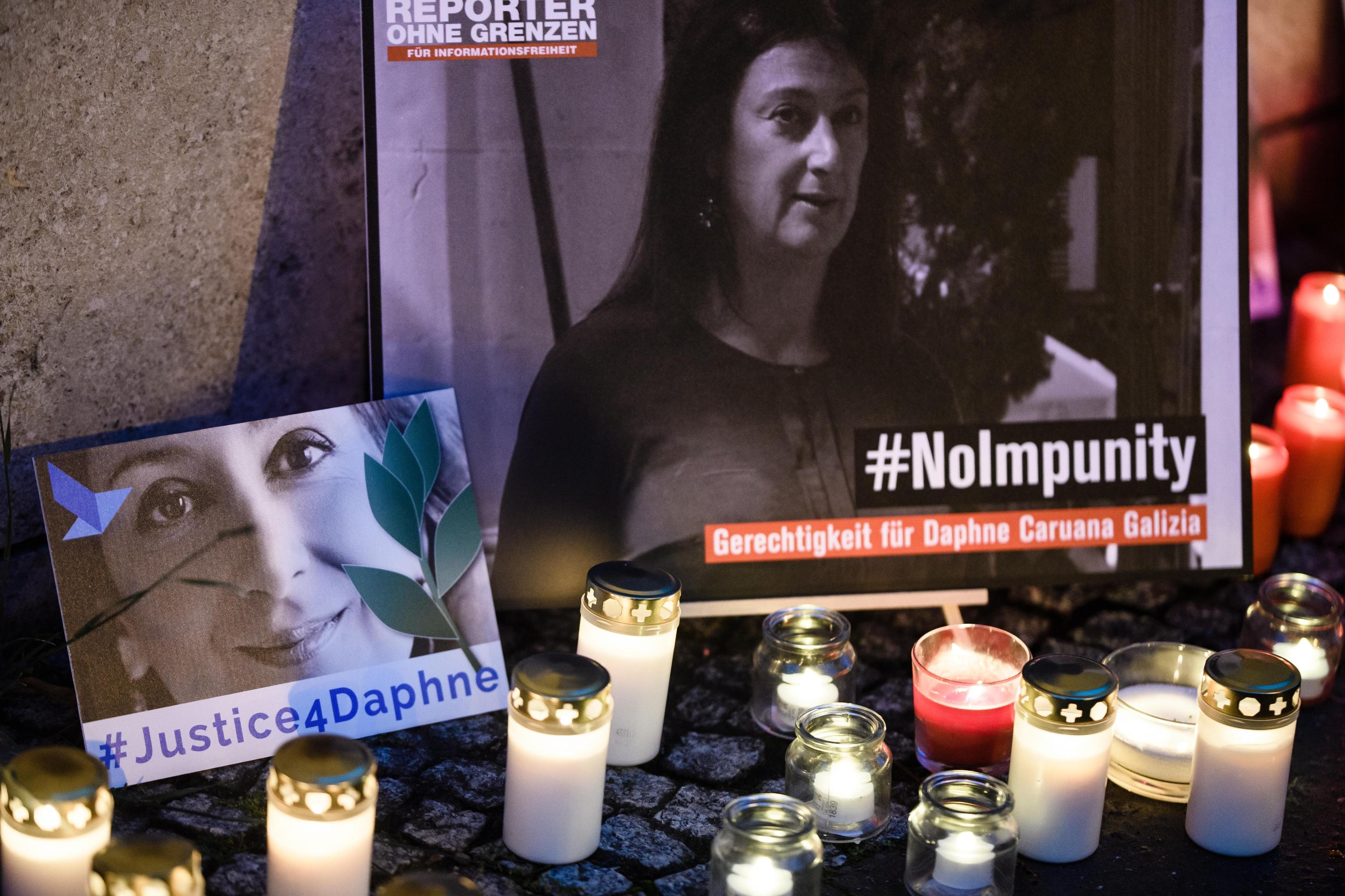 epa07925851 'Justice four Daphne' is written on a cardboard showing a photo of Daphne Caruana Galizia, during a picket in front of the Maltese embassy for murdered journalist Daphne Caruana Galizia in Berlin, Germany, 16 October 2019. Reporters Without Borders organized a picket for murdered journalist Daphne Caruana Galizia, who was killed on 16 October 2017 in Malta, while investigating the Panama Papers case.  EPA/CLEMENS BILAN