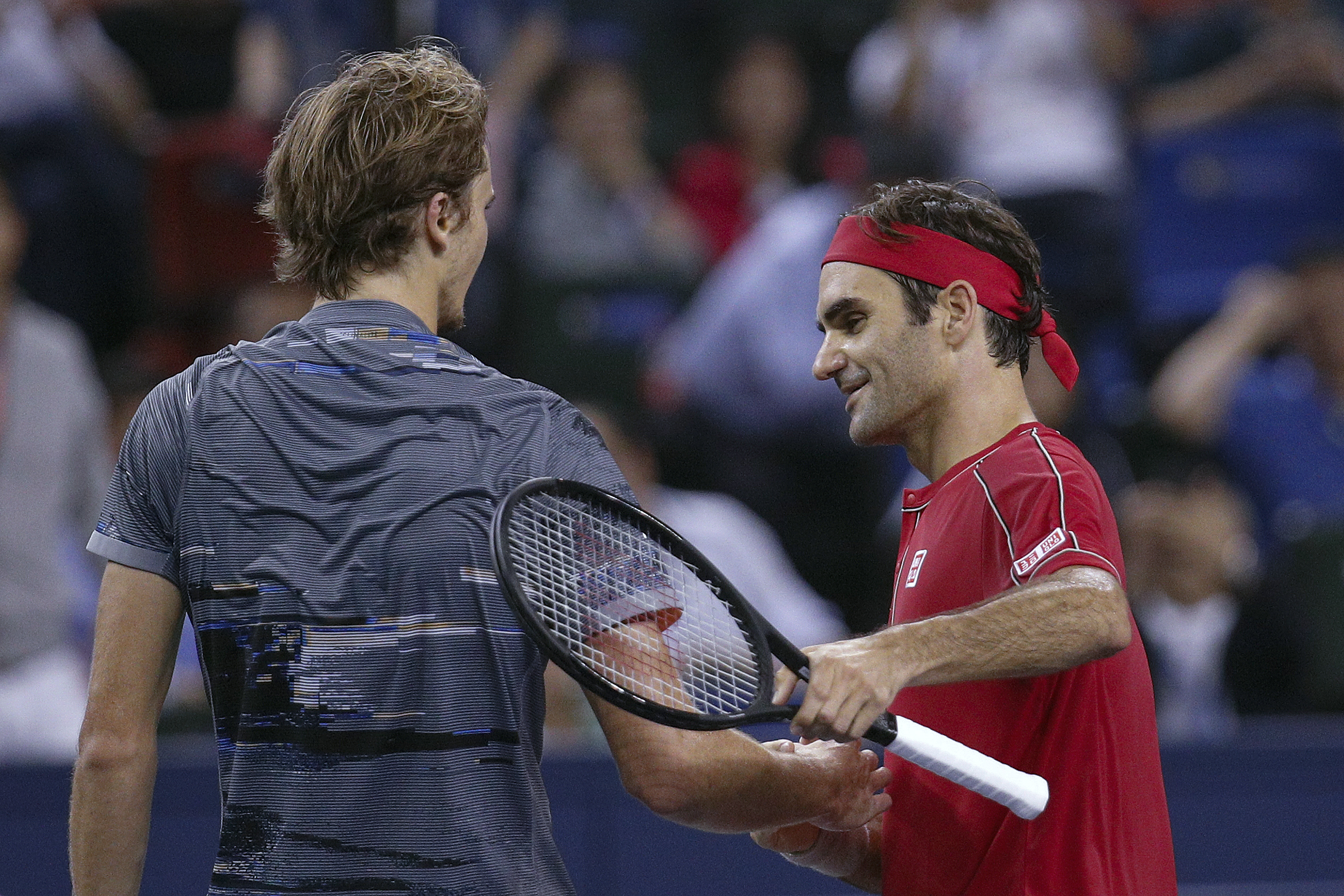 Alexander Zverev of Germany is greeted by Roger Federer of Switzerland after winning in the men's singles quarterfinals match at the Shanghai Masters tennis tournament at Qizhong Forest Sports City Tennis Center in Shanghai, China, Friday, Oct. 11, 2019. (AP Photo/Andy Wong)