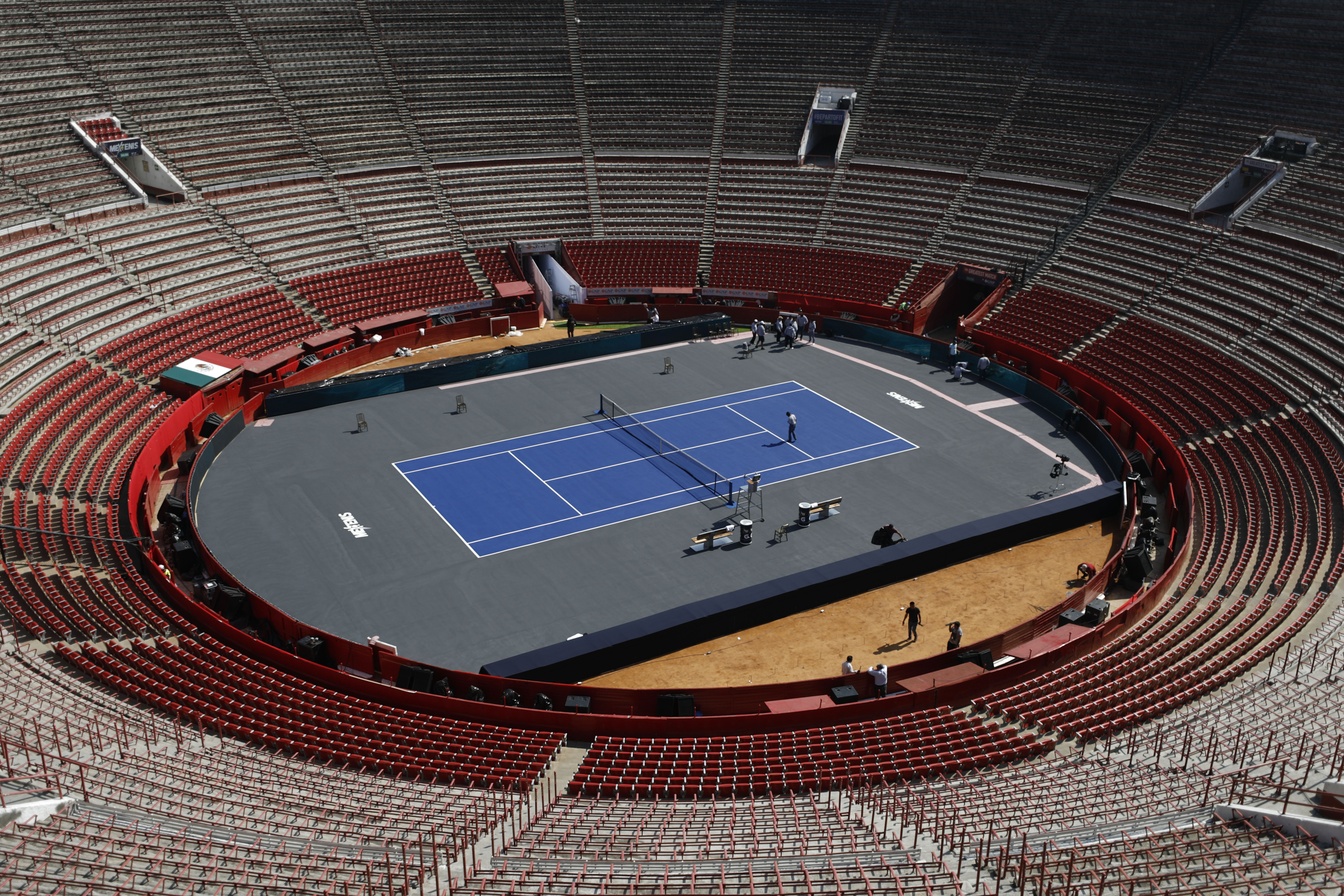 Workers add the finishing touches at the Plaza de Toros bullfighting ring that has been converted into a tennis court to host an exhibition tennis match between Swiss great Roger Federer and German rival Alexander Zverev, in Mexico City, Friday, Nov. 22, 2019. (AP Photo/Rebecca Blackwell)