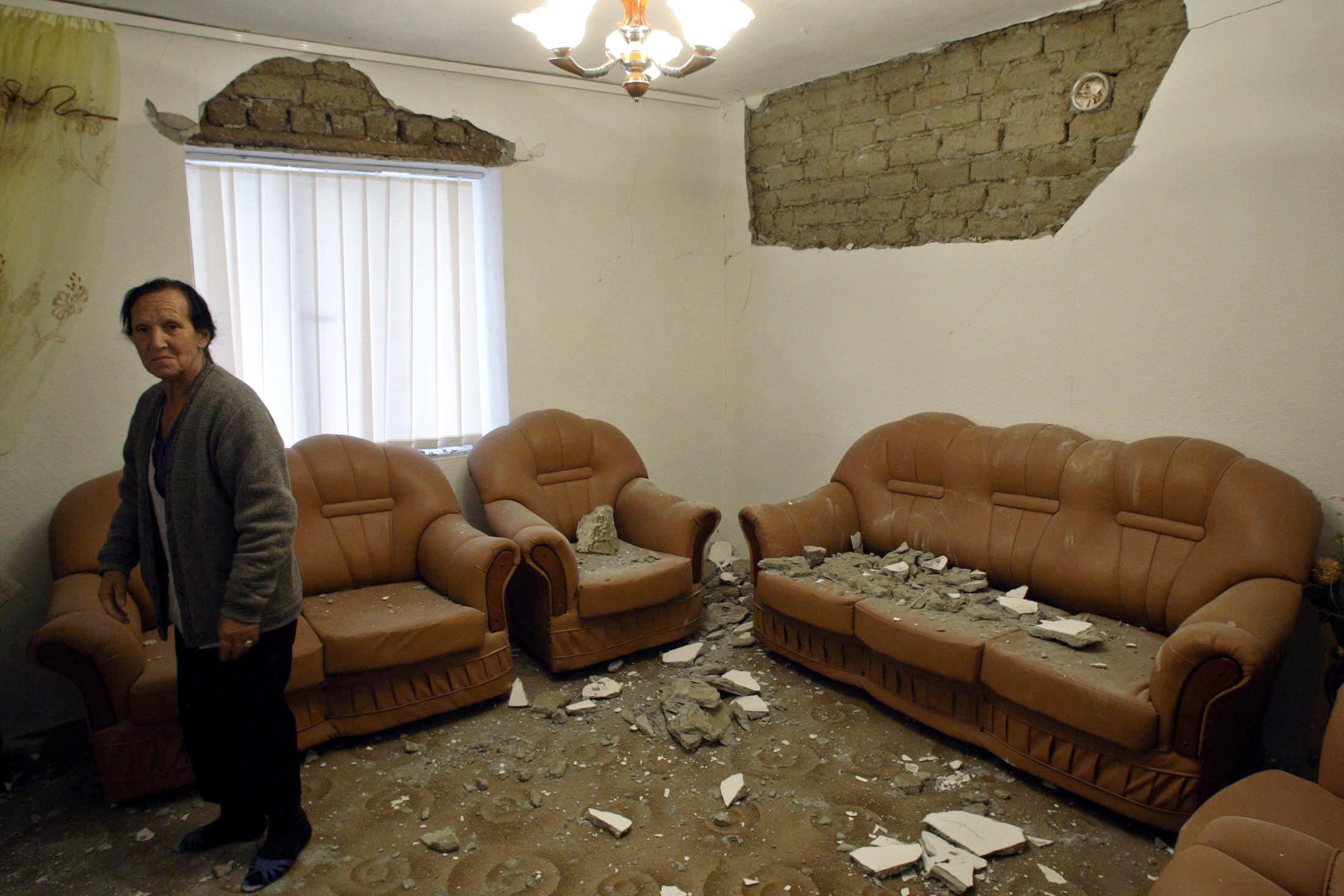 epa01851302 An Albanian woman look at his damaged house in Shupenz near Peshkopi, some 200 km north east from Tirana Albania on 07 September 2009. An earthquake with a preliminary magnitude of 7 in the northeast of the country caused some damage but no injuries as reports say for more than 160 houses destroyed  EPA/ARMANDO BABANI