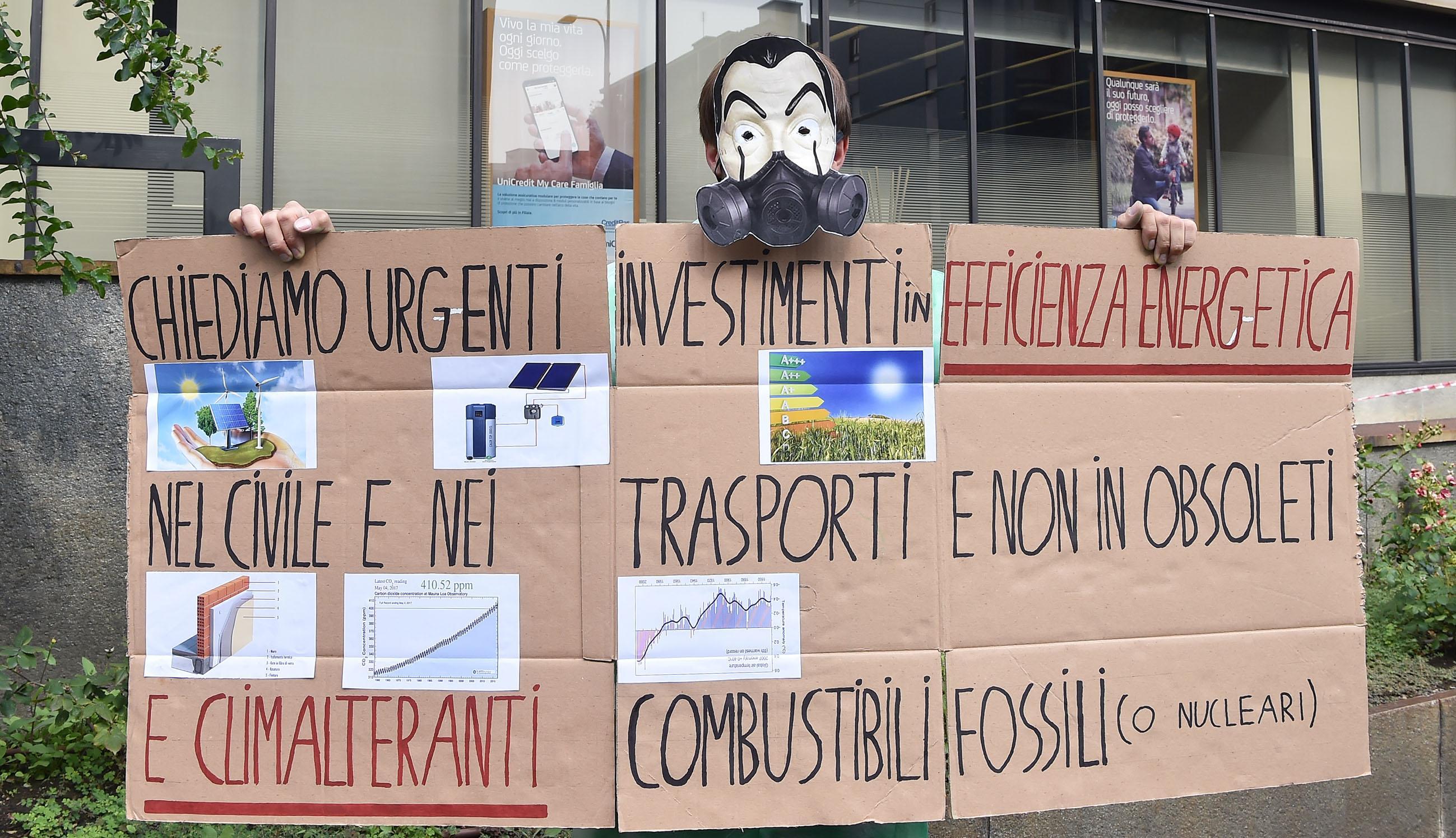 Gli attivisti di Friday for future sotto la sede Unicredit con tute e maschere che ricordano la serie tv 